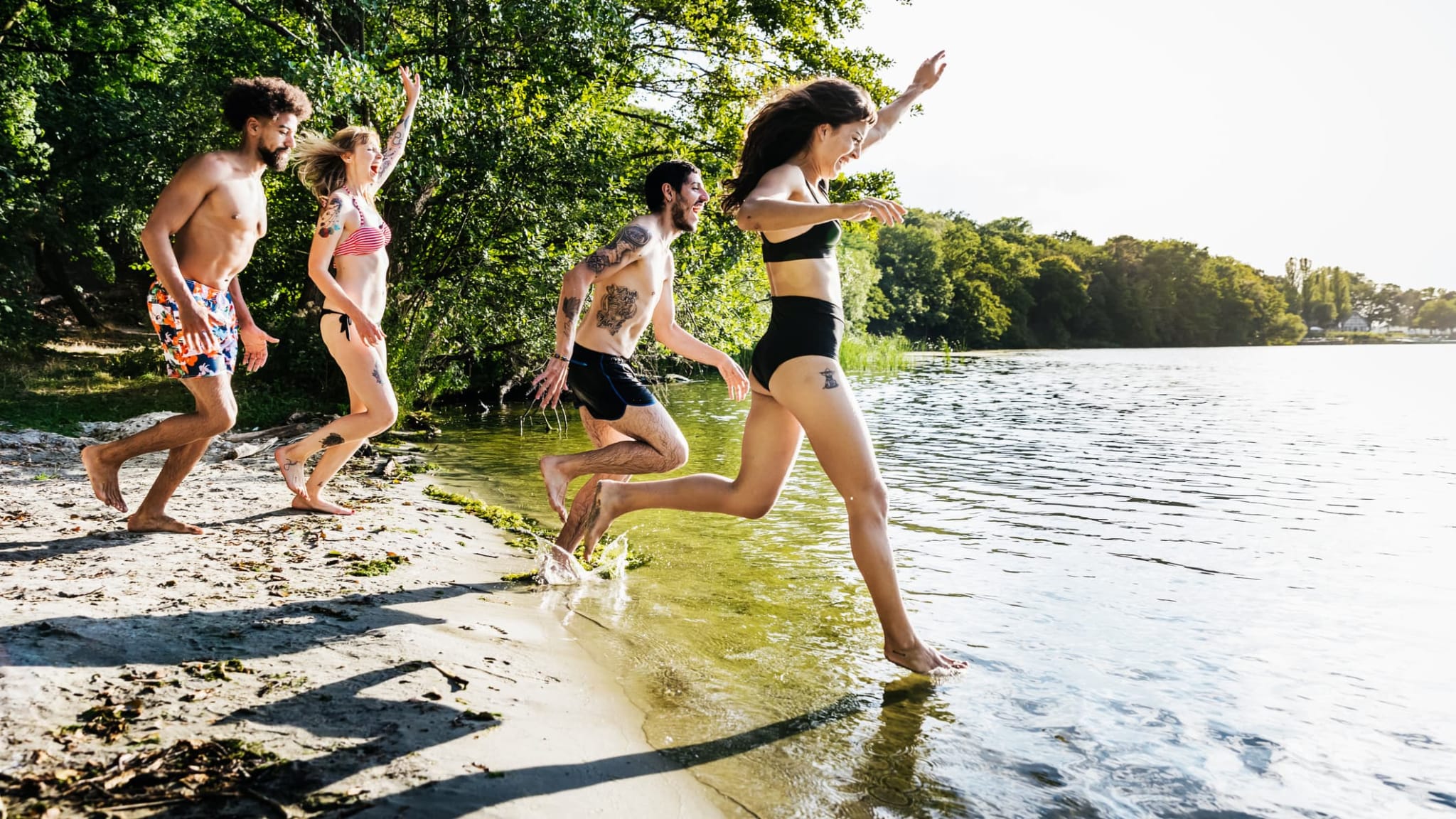 Eine Gruppe von Freunden rennt in einen See.