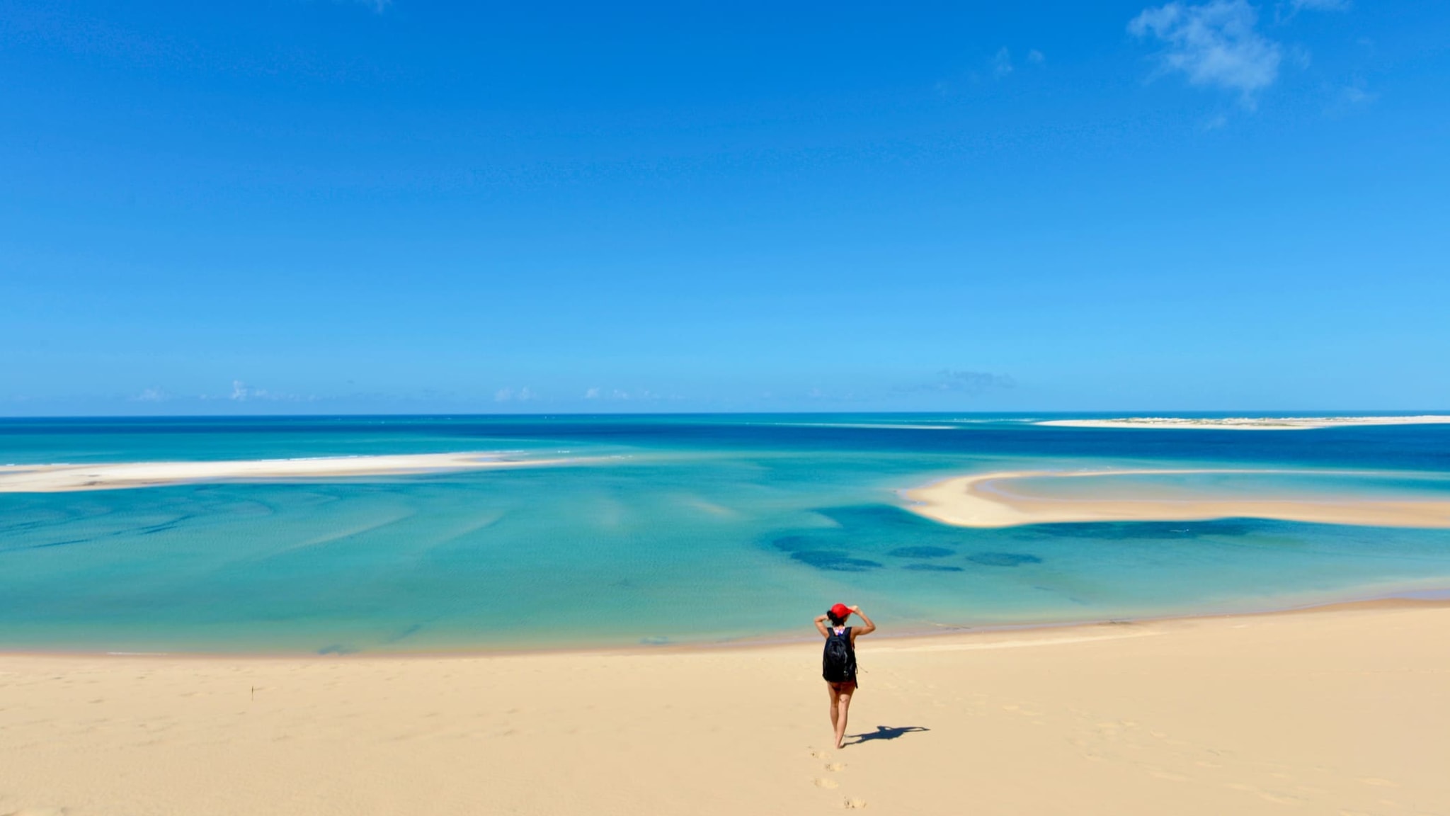Eine junge Frau steht vor dem Meer an einem Strand in Mozambique.