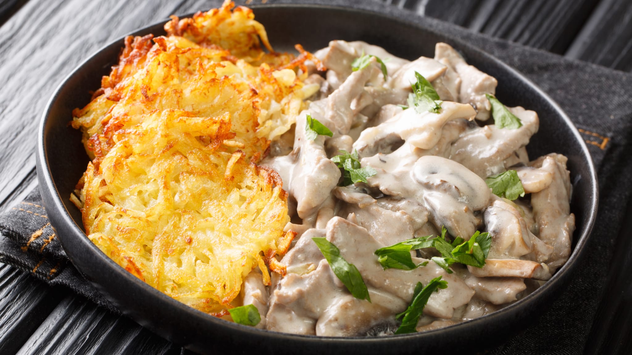Eine Portion Zürcher Geschnetzeltes mit Kartoffelrösti. © ALLEKO/iStock / Getty Images Plus via Getty Images