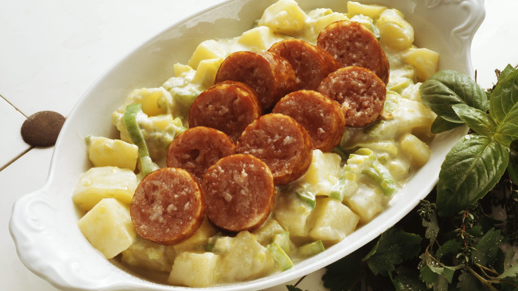 Eine Schale Saucisson Vaudois mit Lauchgemüse. © Image Professionals / Eising Studio - Food Photo & Video