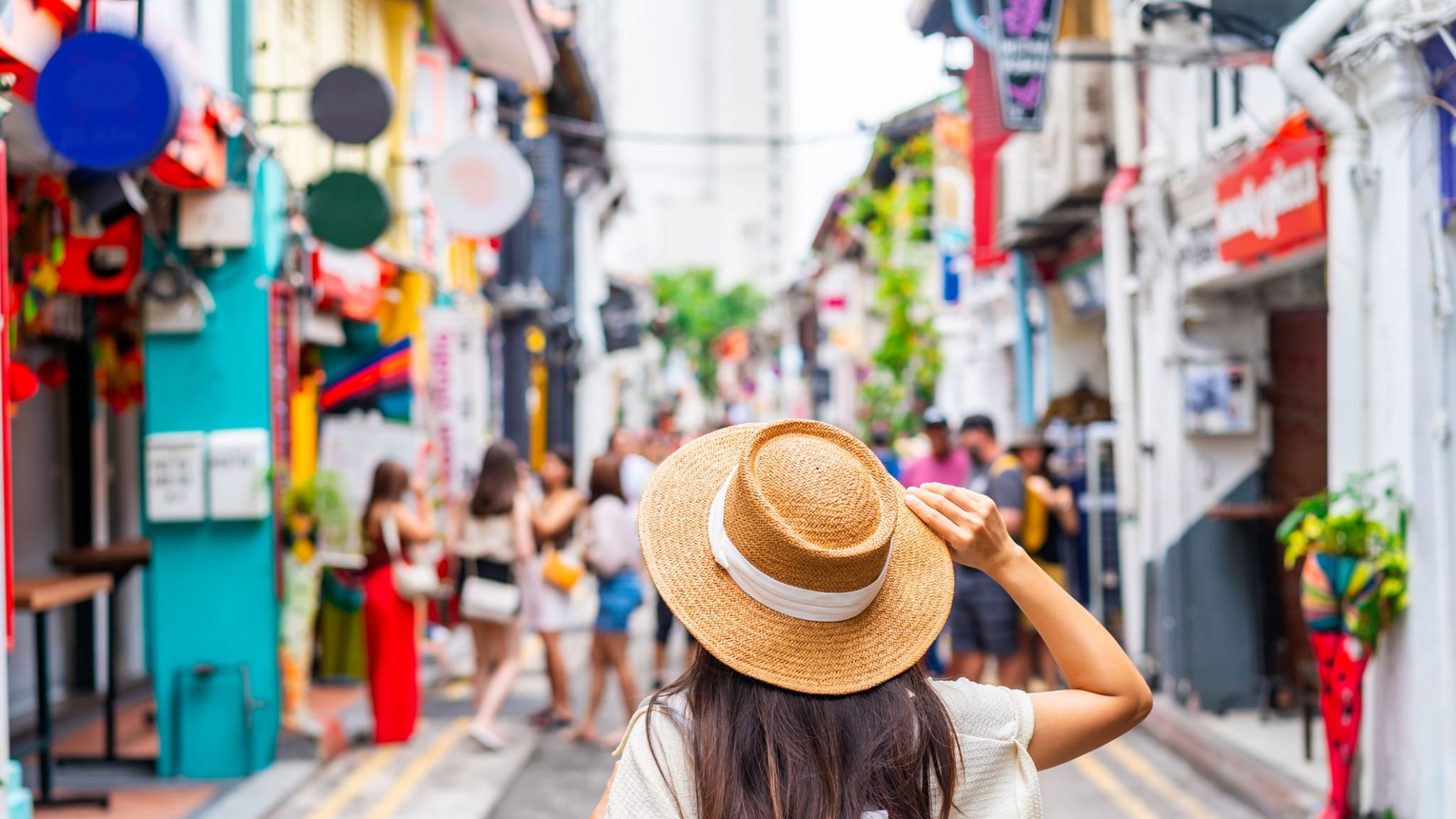 Eine Touristin läuft alleine durch eine Einkaufsstraße in Singapur.