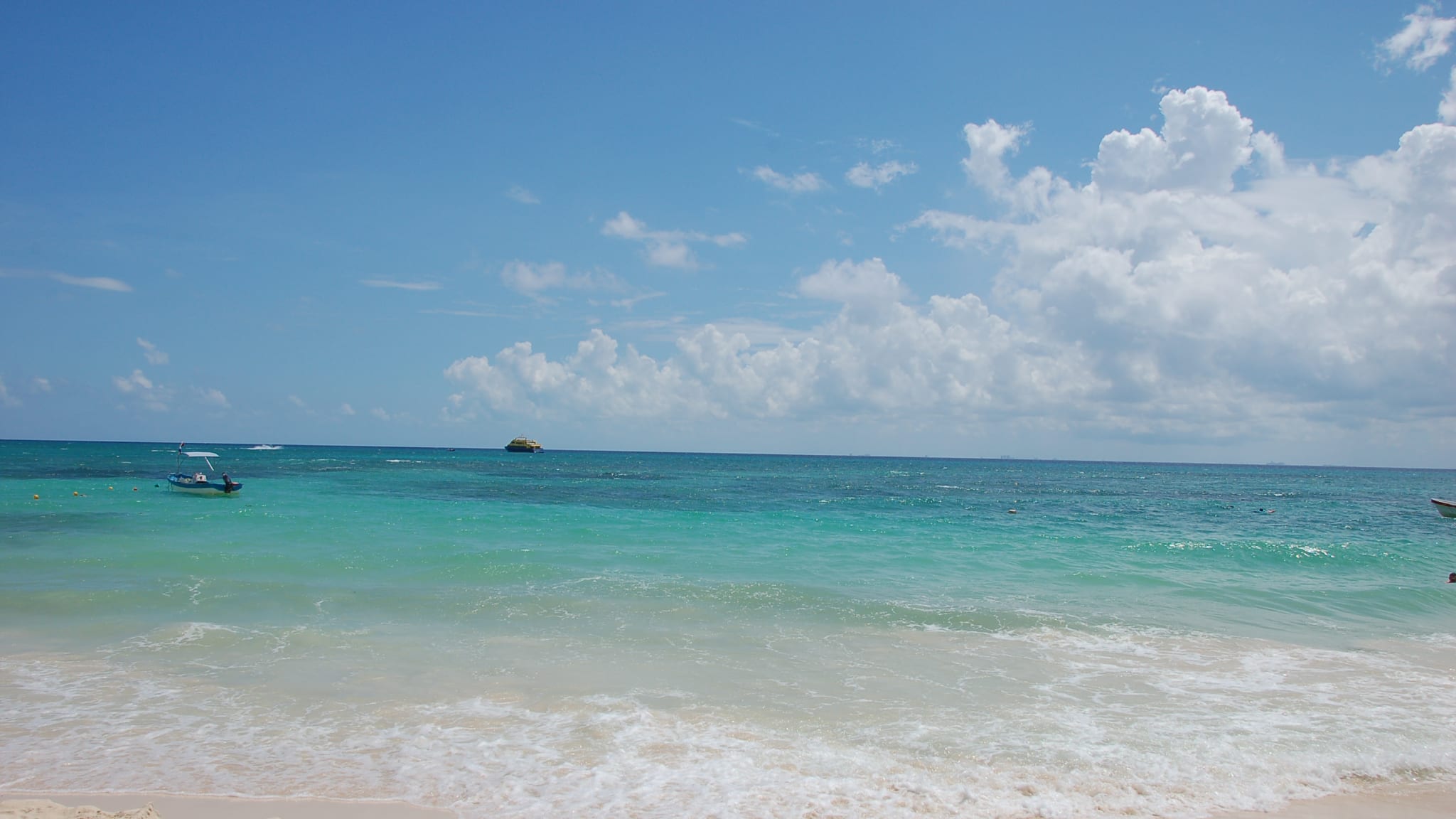 Einige Boote drehen ihre Runden auf dem türkisfarbenen Meer. © musseln/iStock / Getty Images Plus via Getty Images