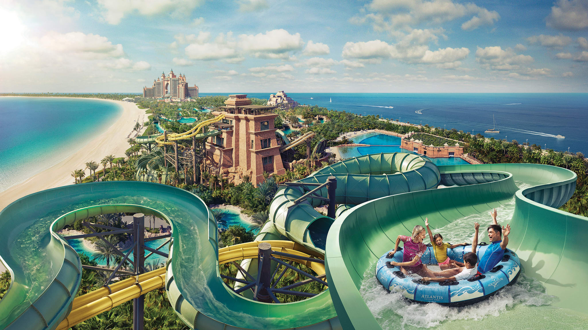 Familie saust im Riesen-Reifen XL-Rutsche hinab, im Hintergrund Dubais Atlantis-Hotel