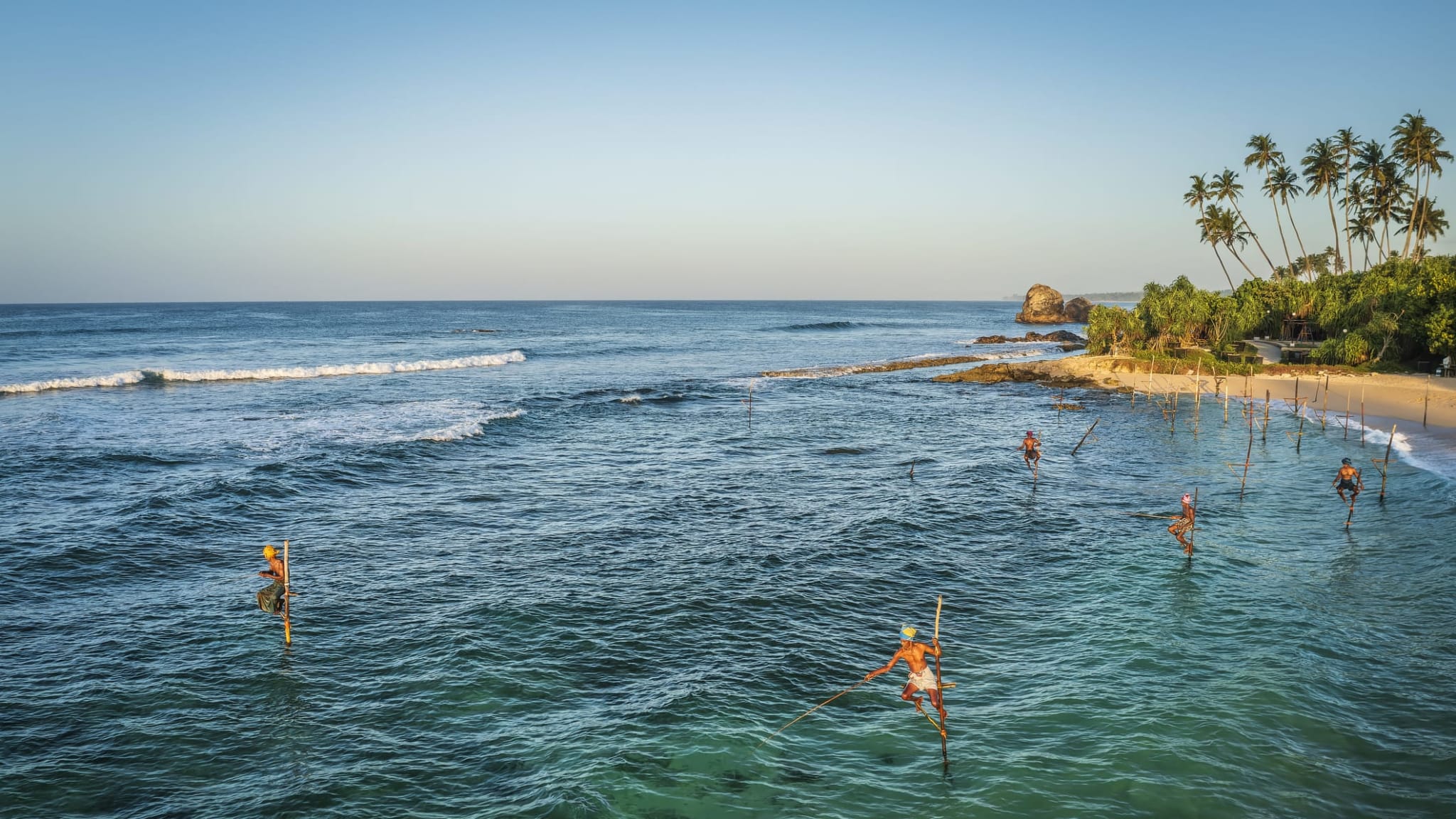 Fischer auf Stelzen im Meer in Thailand.