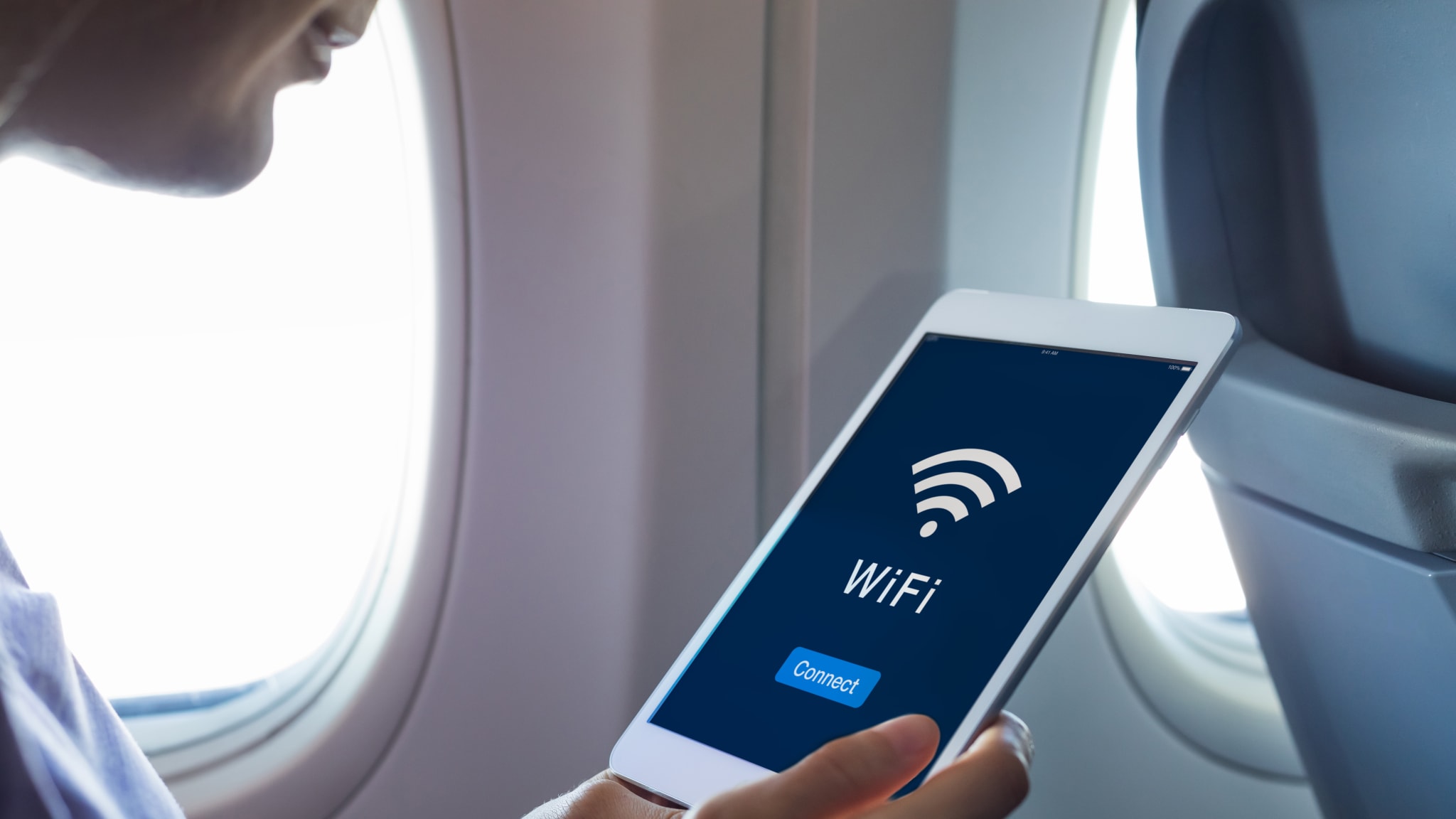 Ein Tablet wird mit dem Wlan auf einem Flugzeug verbunden