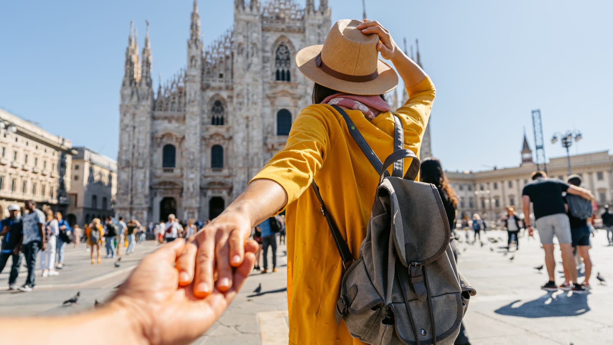 Eine Frau hält die Hand von ihrem Partner vor der Kathedrale in Mailand.