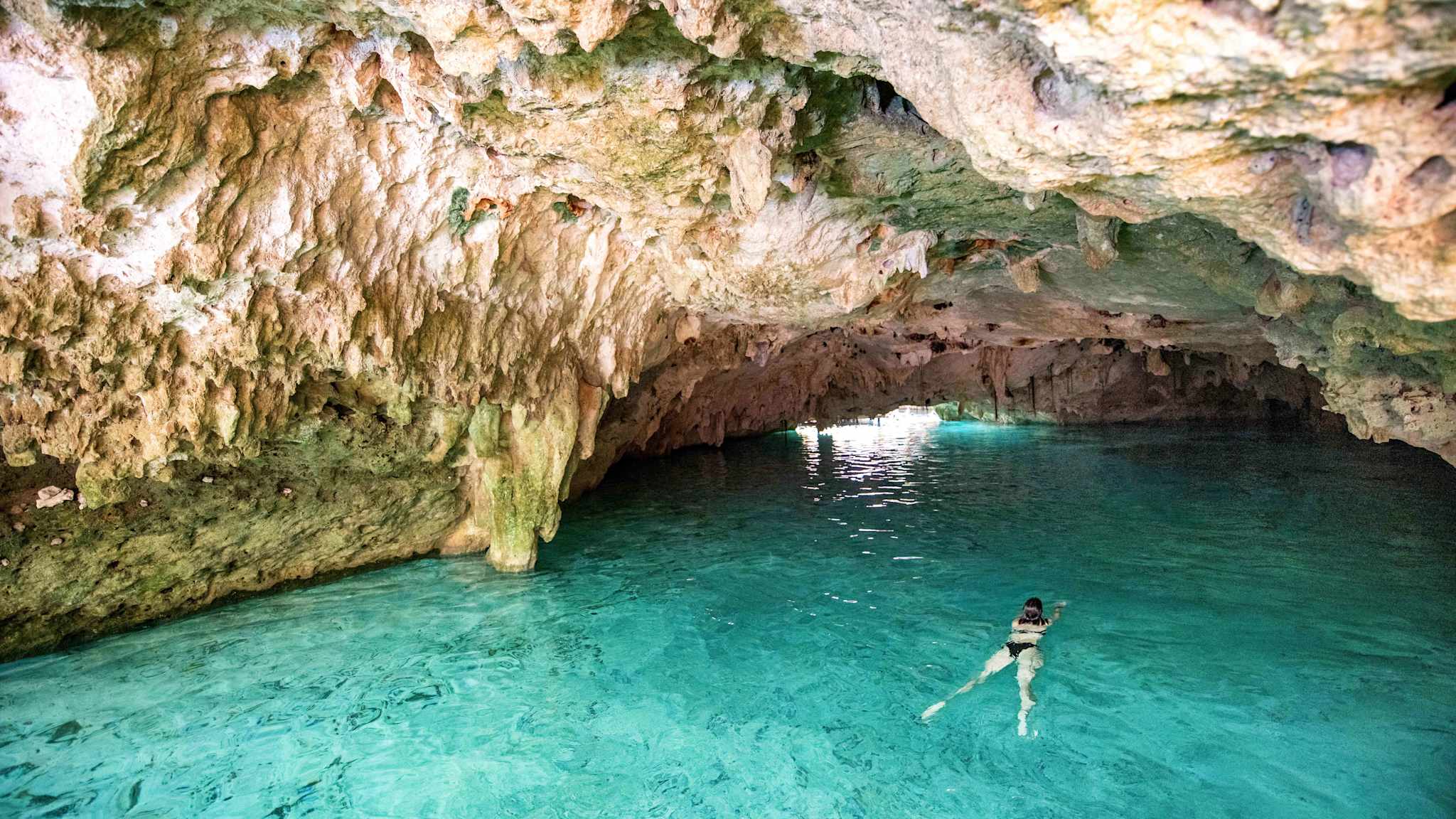 Eine Frau schwimmt in einer Cenote in Cancun, Mexico.