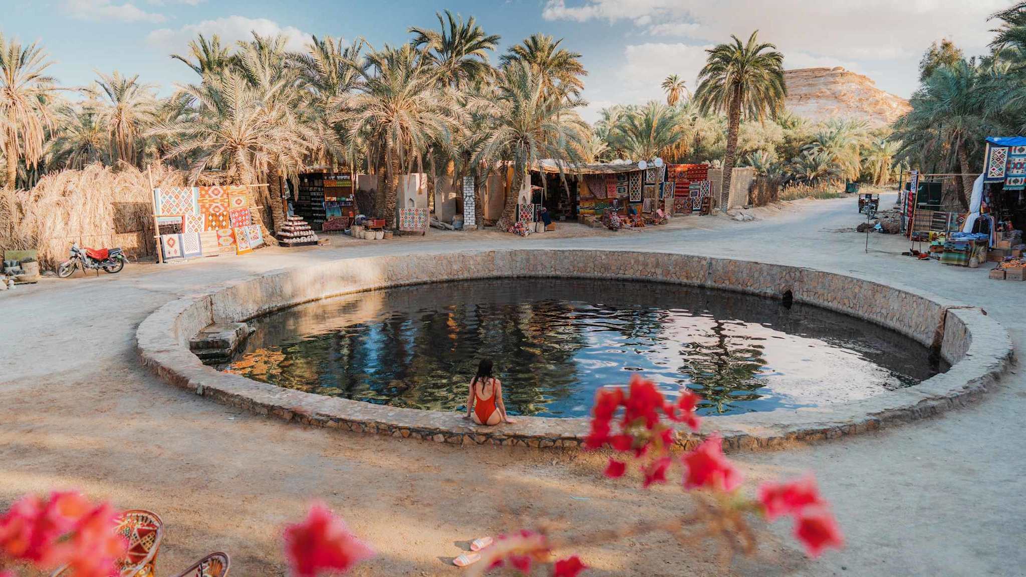 Eine Frau entspannt in einem natürlichen Pool in der Siwa-Oase.