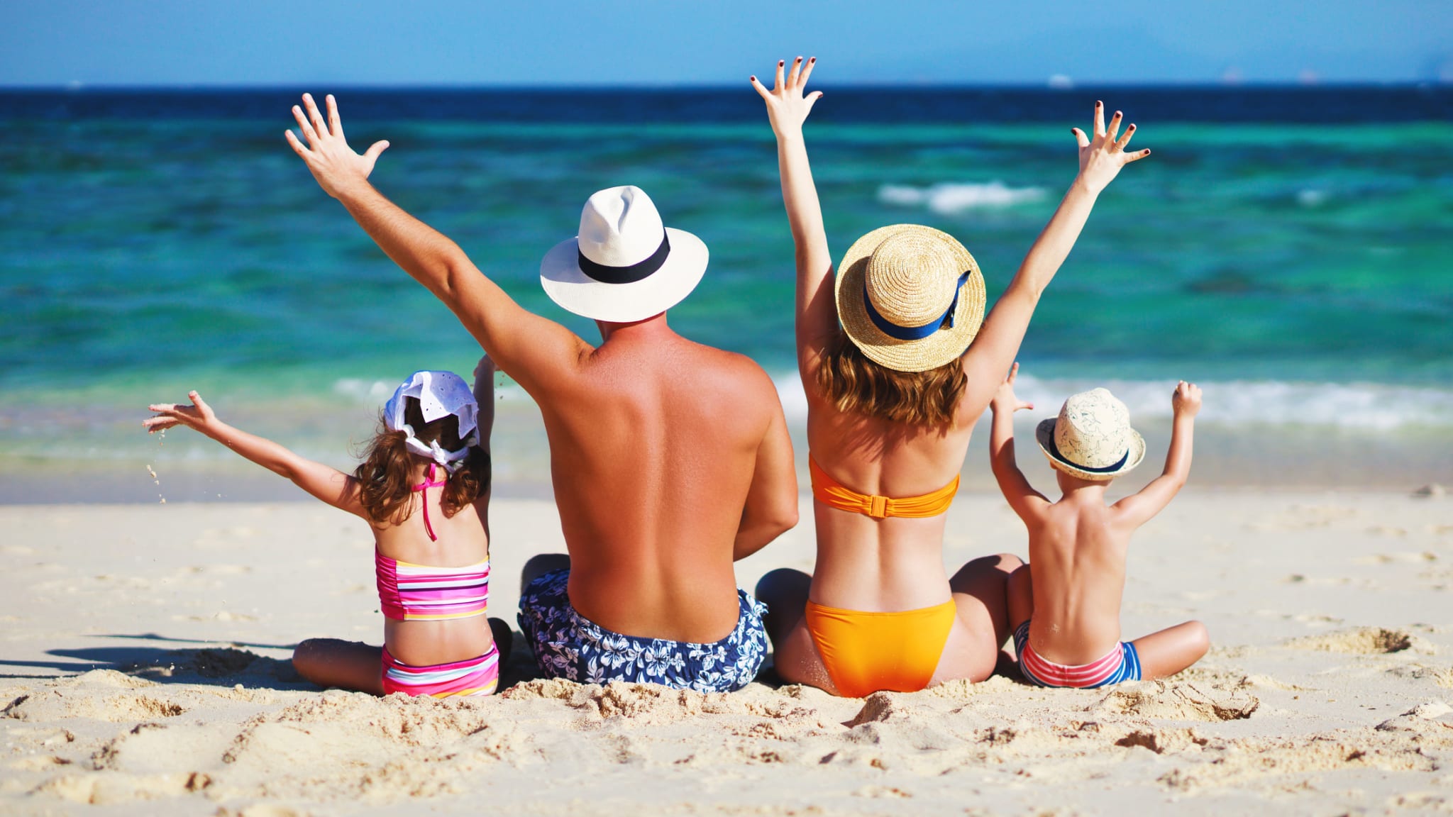 glückliche Familie mit Vater Mutter und Kindern sitzen am Strand © iStock.com/evgenyatamanenko