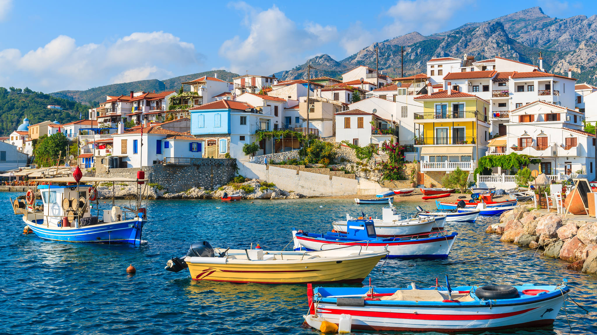 Hafen von Kokkari auf Sámos mit bunten Fischerbooten im Wasser in Griechenland