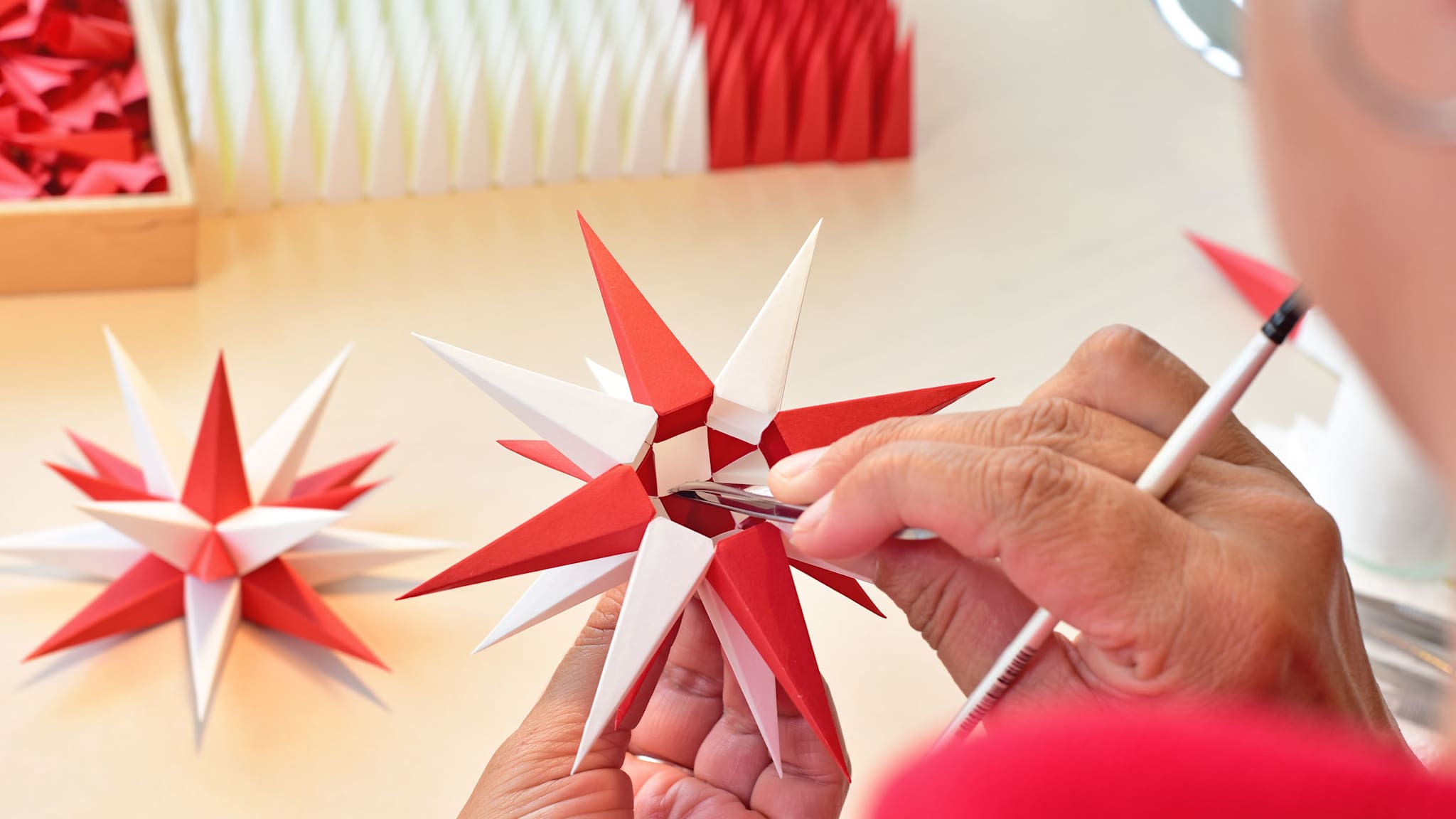 Eine Frau bastelt einen Papierstern.