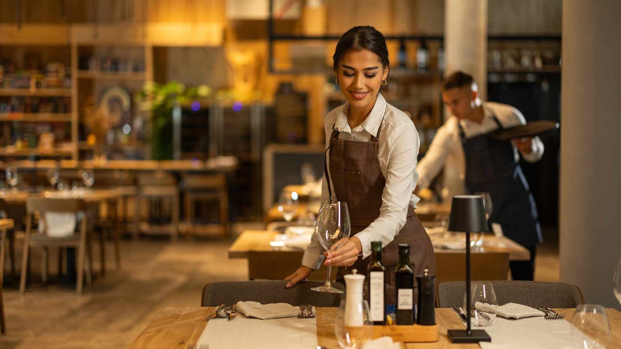 Eine Kellnerin deckt einen Tisch in einem Restaurant.