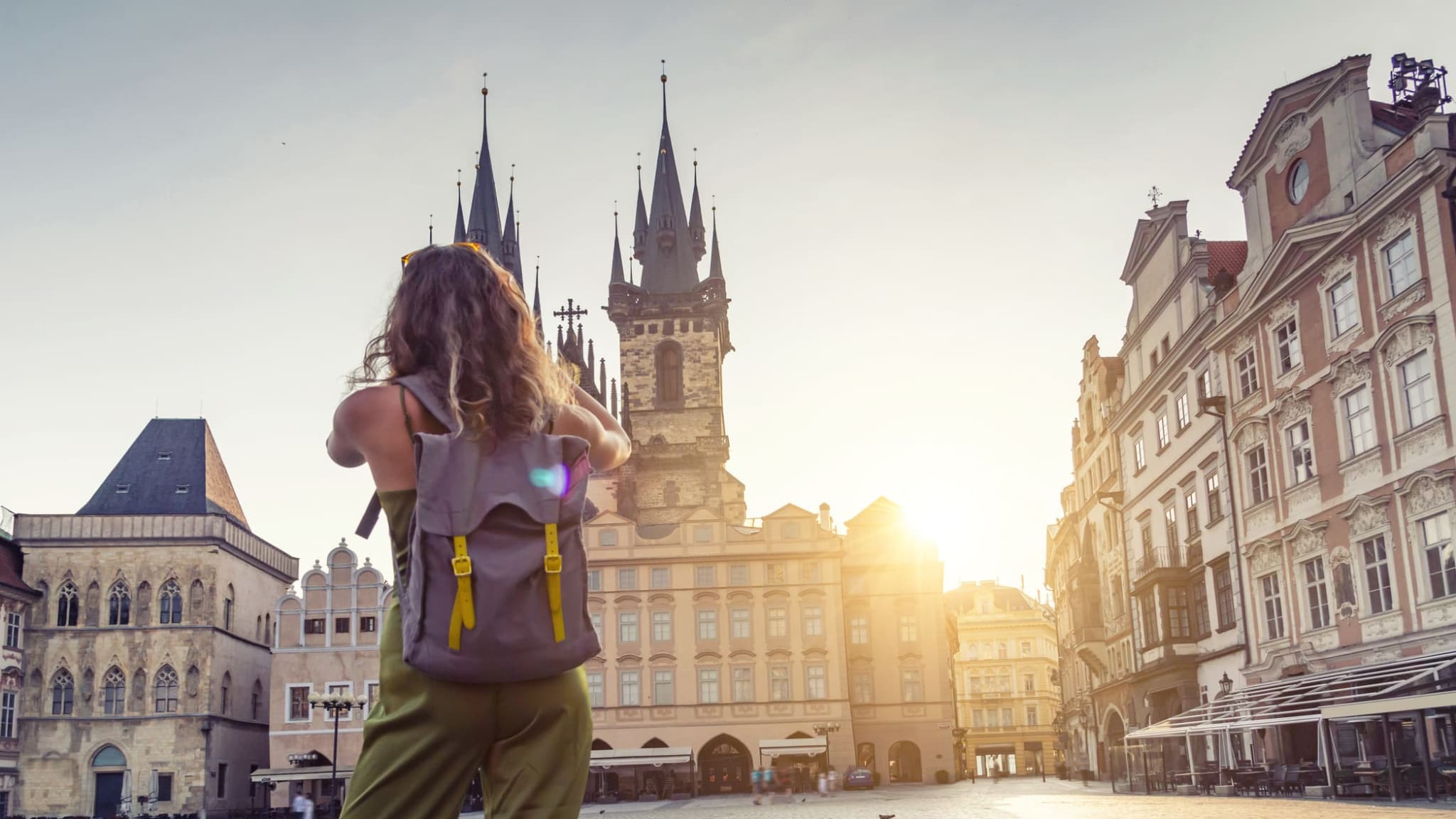 Eine junge Frau macht ein Foto der Tyn Kirche in Prag.