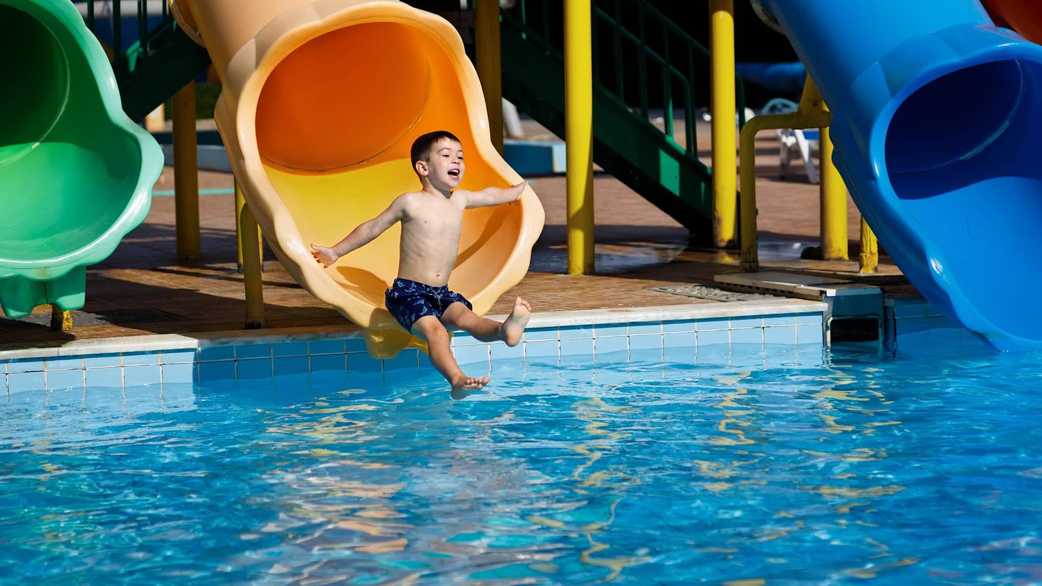 Junge rutscht auf einer Rutsche im Aquapark.