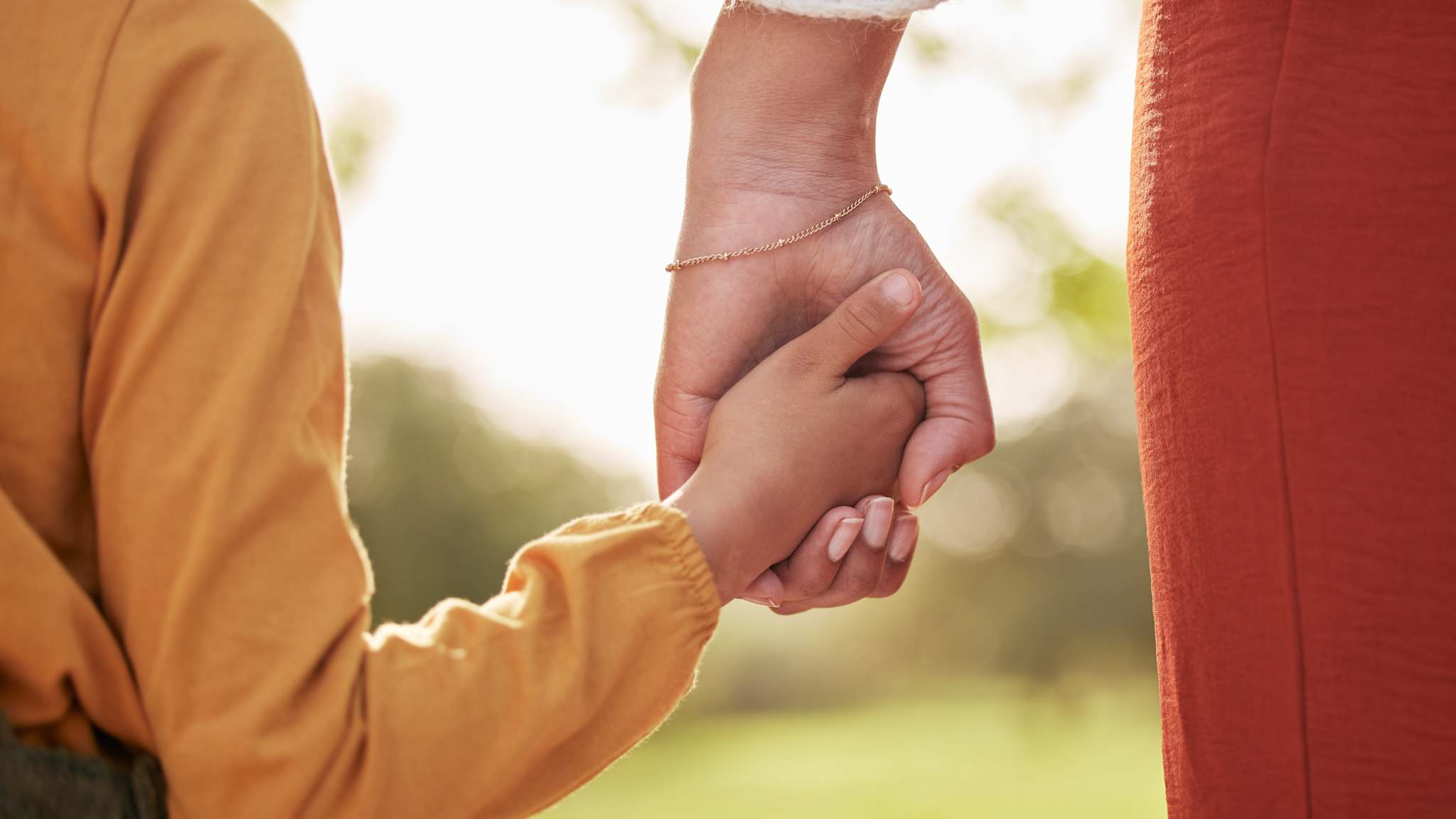 Frau hält die Hand eines Kindes