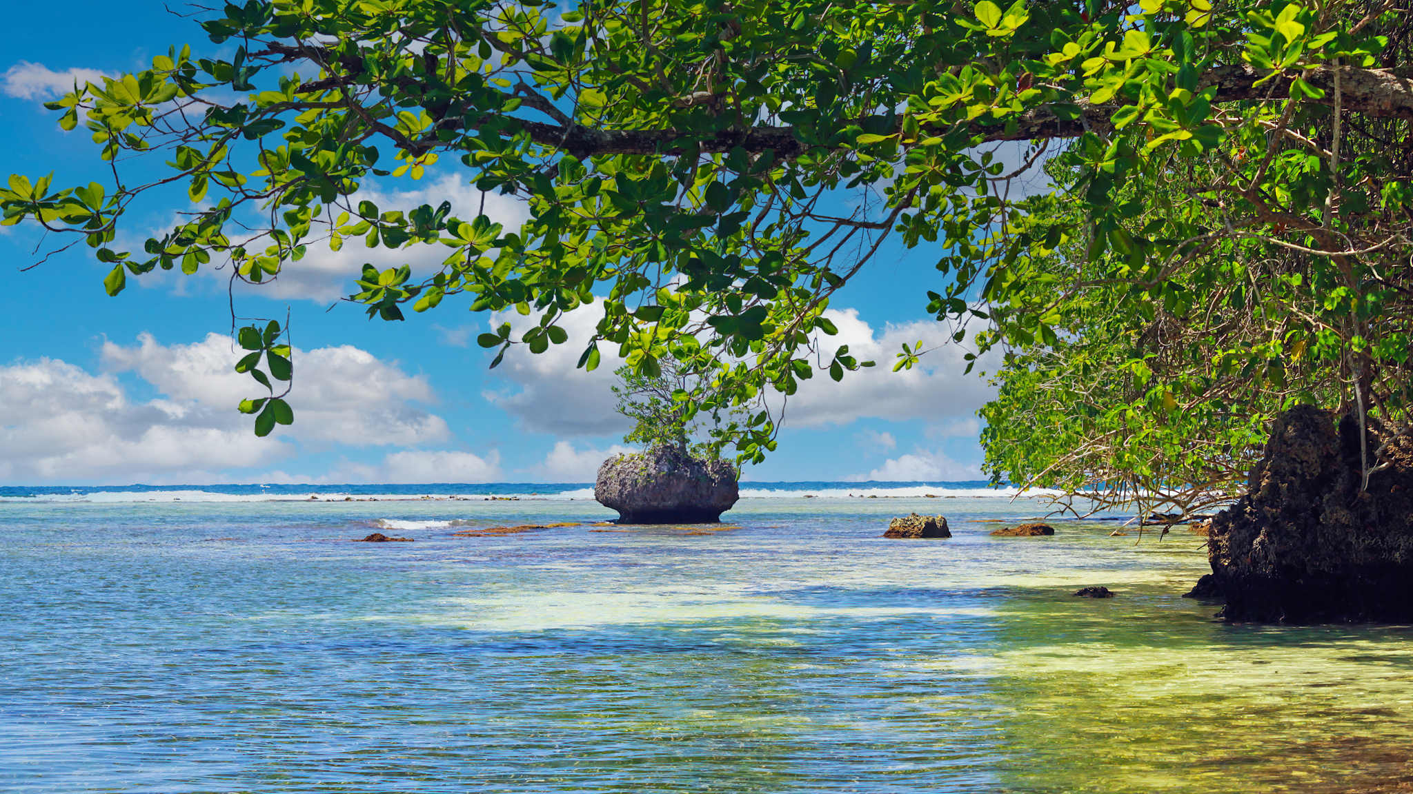 Eine Lagune mit flachem Wasser und Felsen.