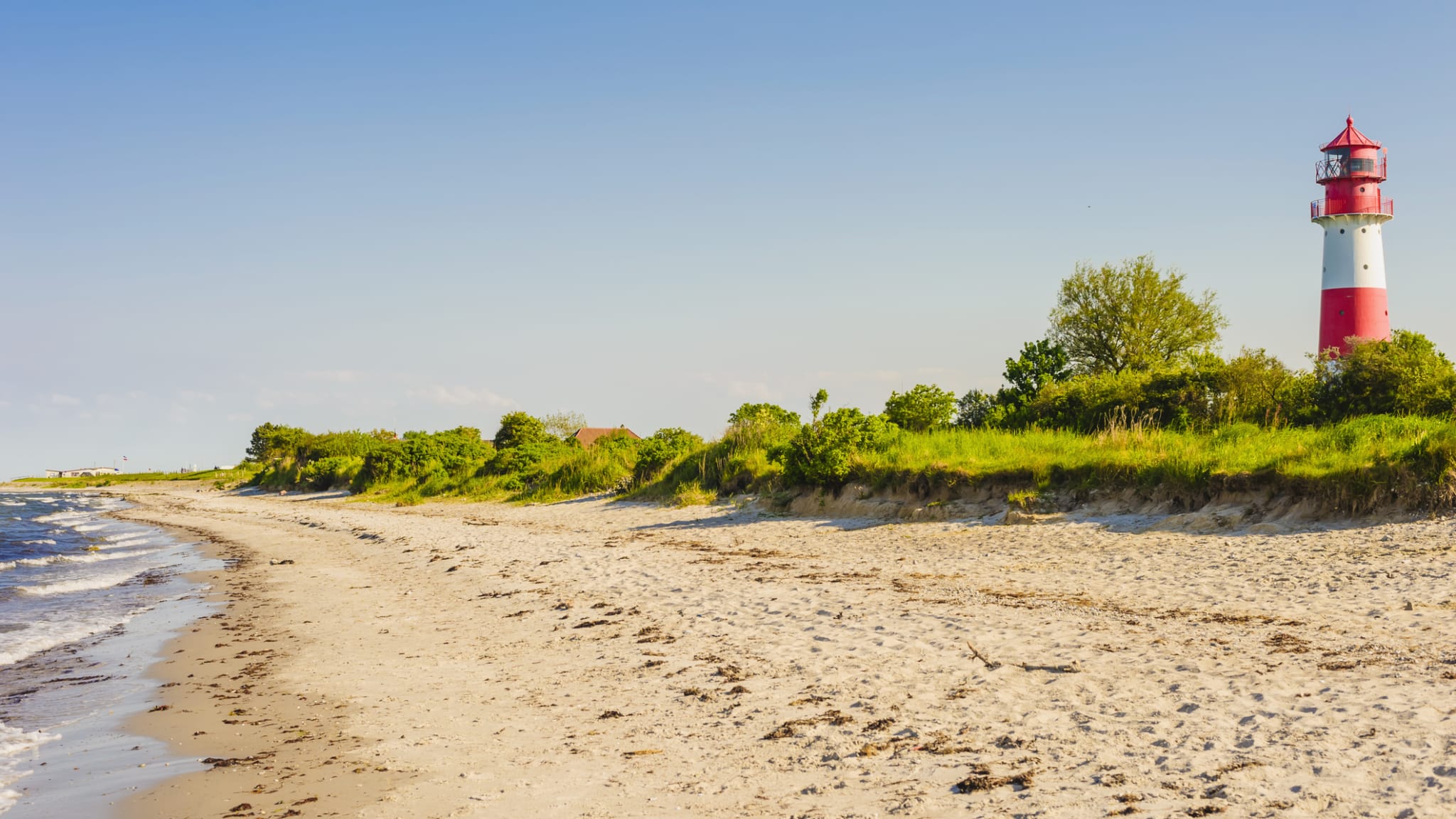 Ein Leuchtturm an einem Strand in Schleswig-Holstein, Deutschland. © Westend61/Westend61 via Getty Images