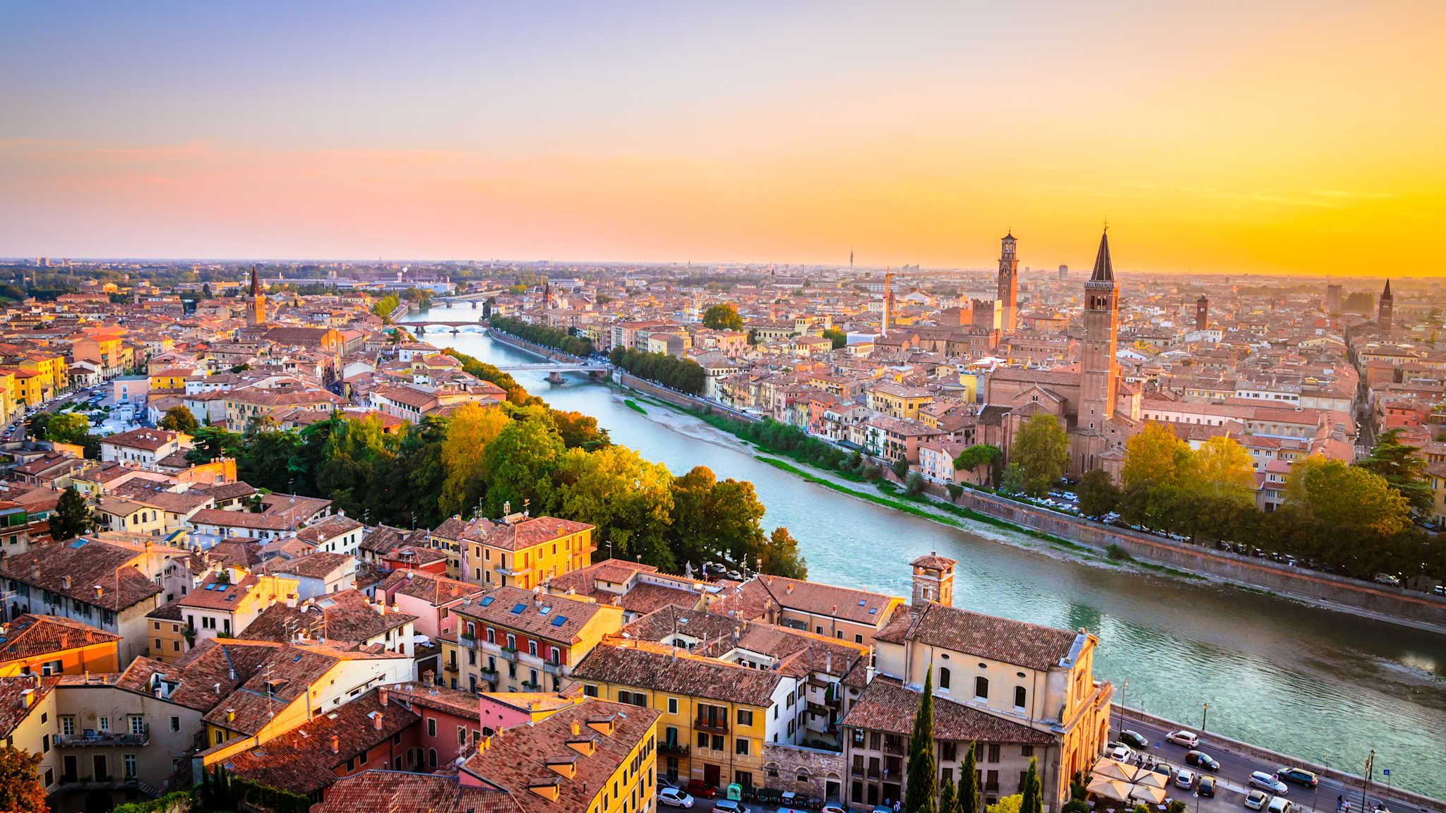 Luftbild einer Stadt mit einem Fluss und vielen Kirchtürmen.
