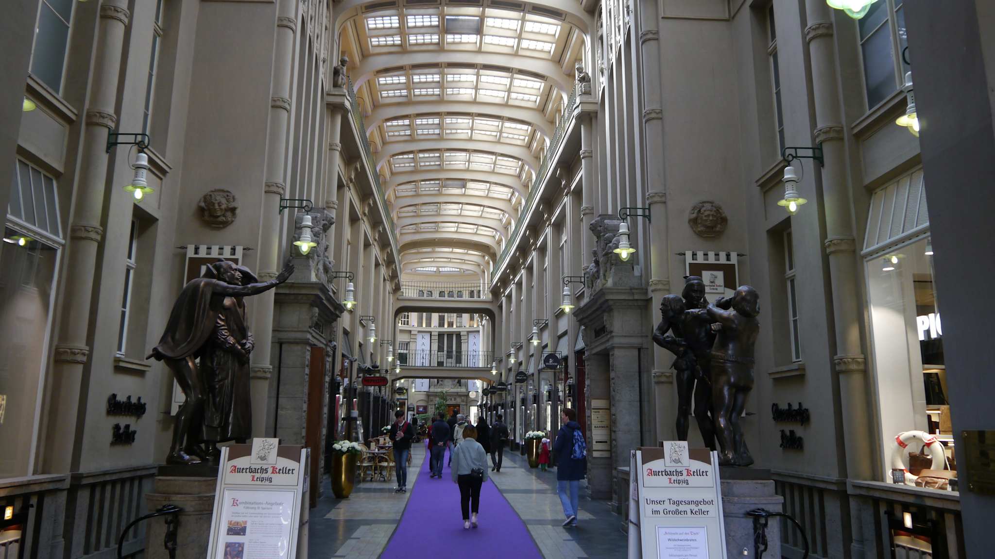 Eine Shopping-Passage mit bronze Statuen