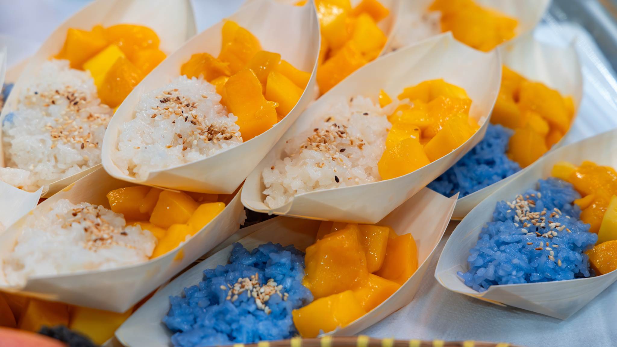 Ein Mango-Reis-Gericht steht in kleinen Papierschalen bereit.