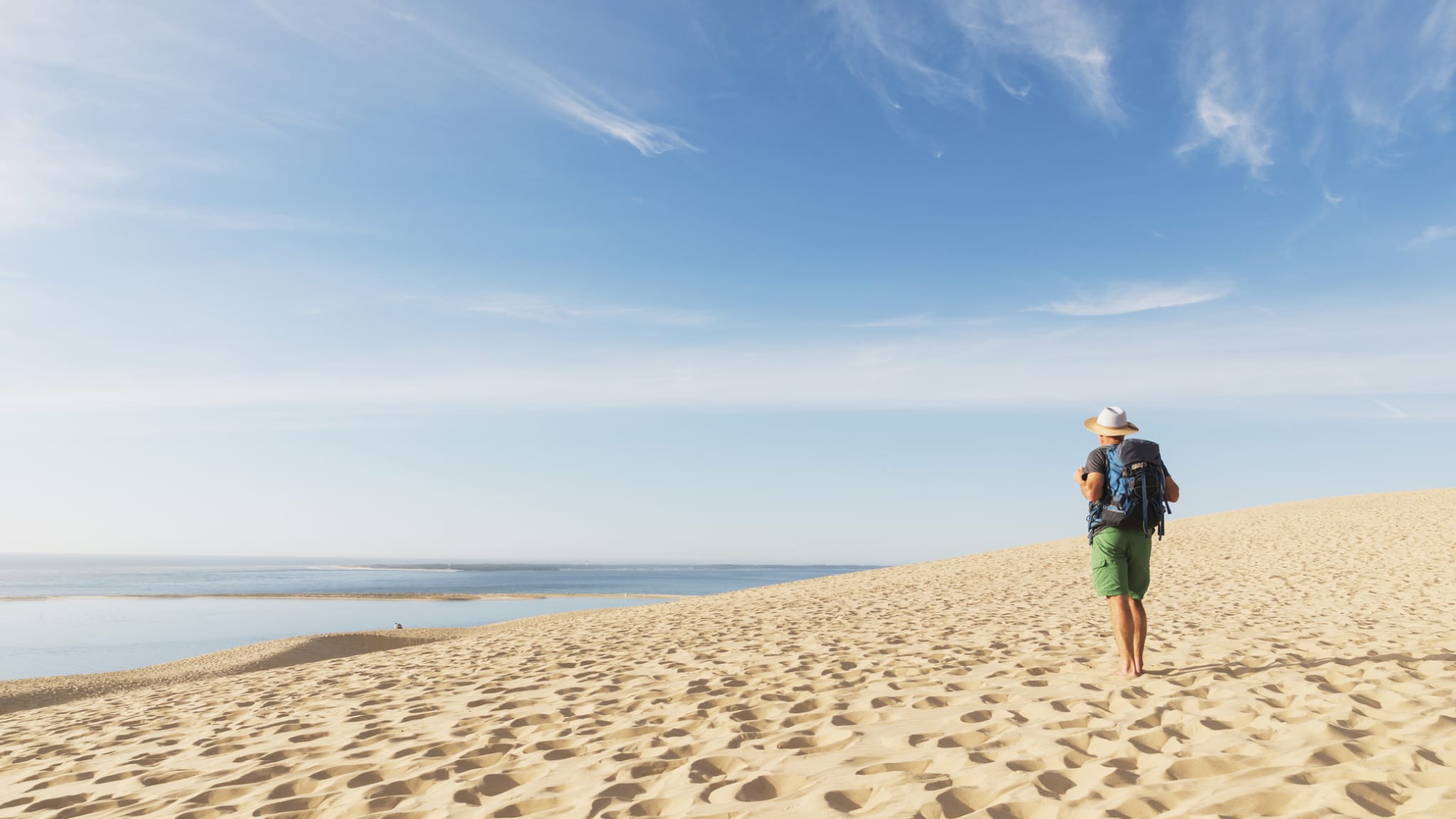 Mann betrachtet den Atlantischen Ozean auf dem Dune du Pilat, Frankreich. © Westend61/Westend61 via Getty Images