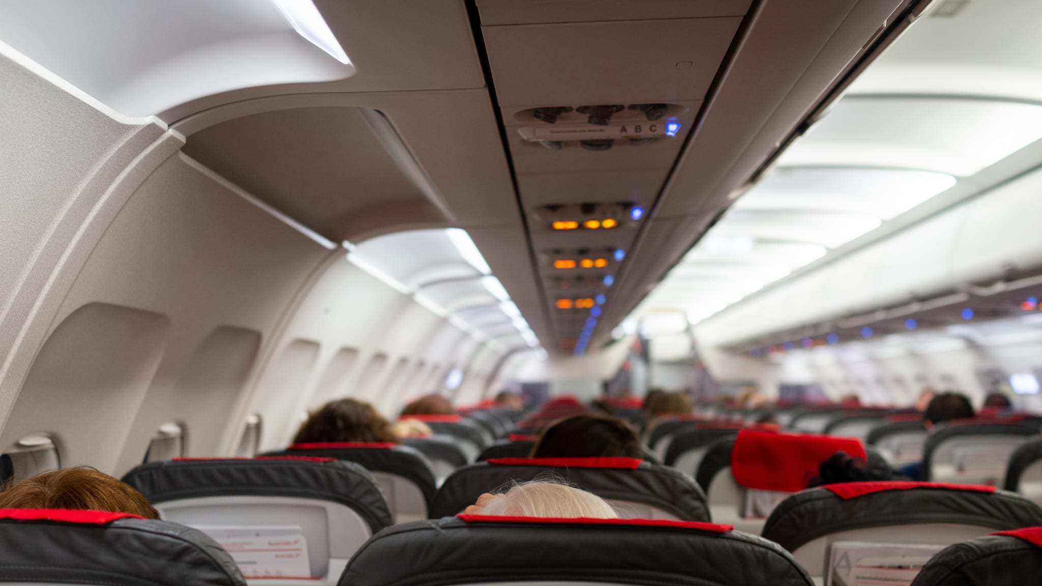 Menschen sitzen in einem Flugzeug. © gettyimages.de - Jasmin Merdan