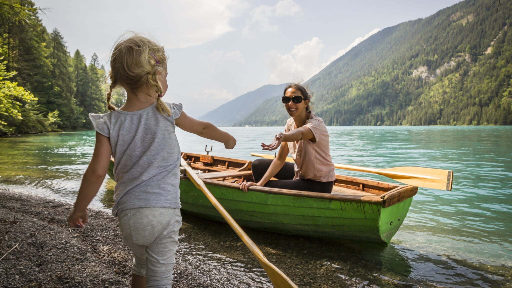 Mutter und Kind mit einem Boot am Ufer des Weissensee, Kärnten, Österreich.