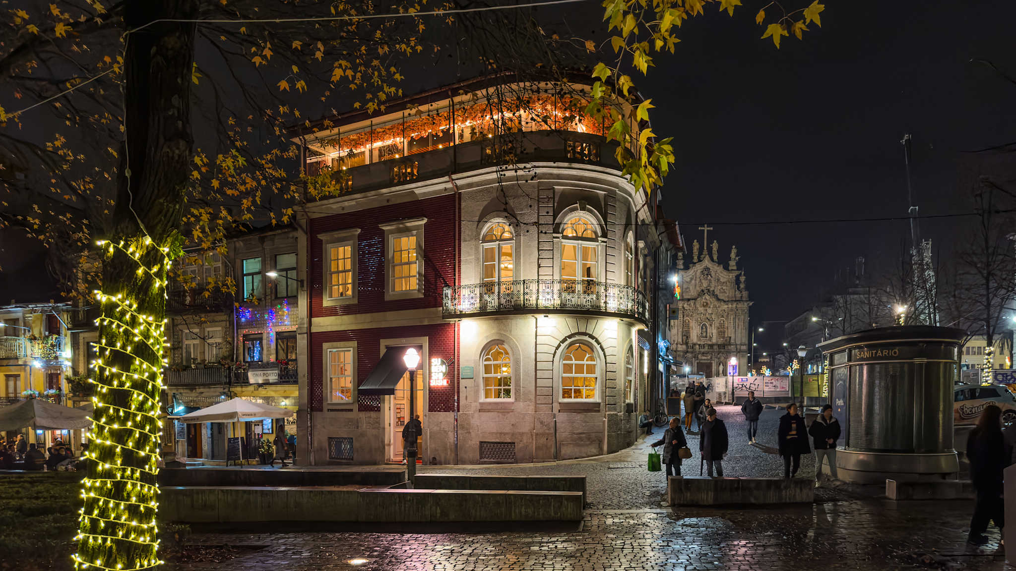 Anwohner und Besucher spazieren durch die Straßen, um die Weihnachtsbeleuchtung und den mit Lichtern geschmückten Musikpavillon des Cordoaria-Gartens zu sehen, Porto, Portugal. © AnaMOMarques via Getty Images
