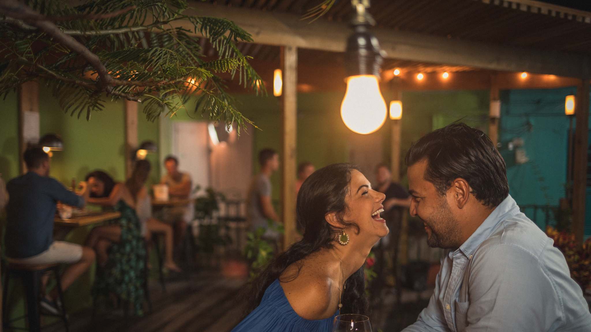 Ein Paar sitzt an einem Tisch und lacht.