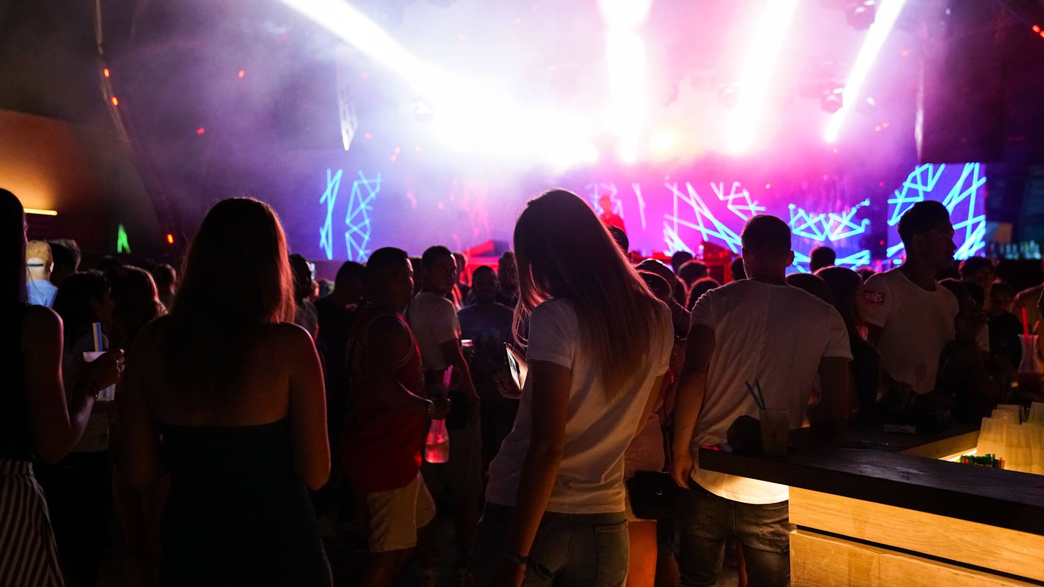 Eine Party findet am Strand statt, die Scheinwerfer erhellen die Umgebung