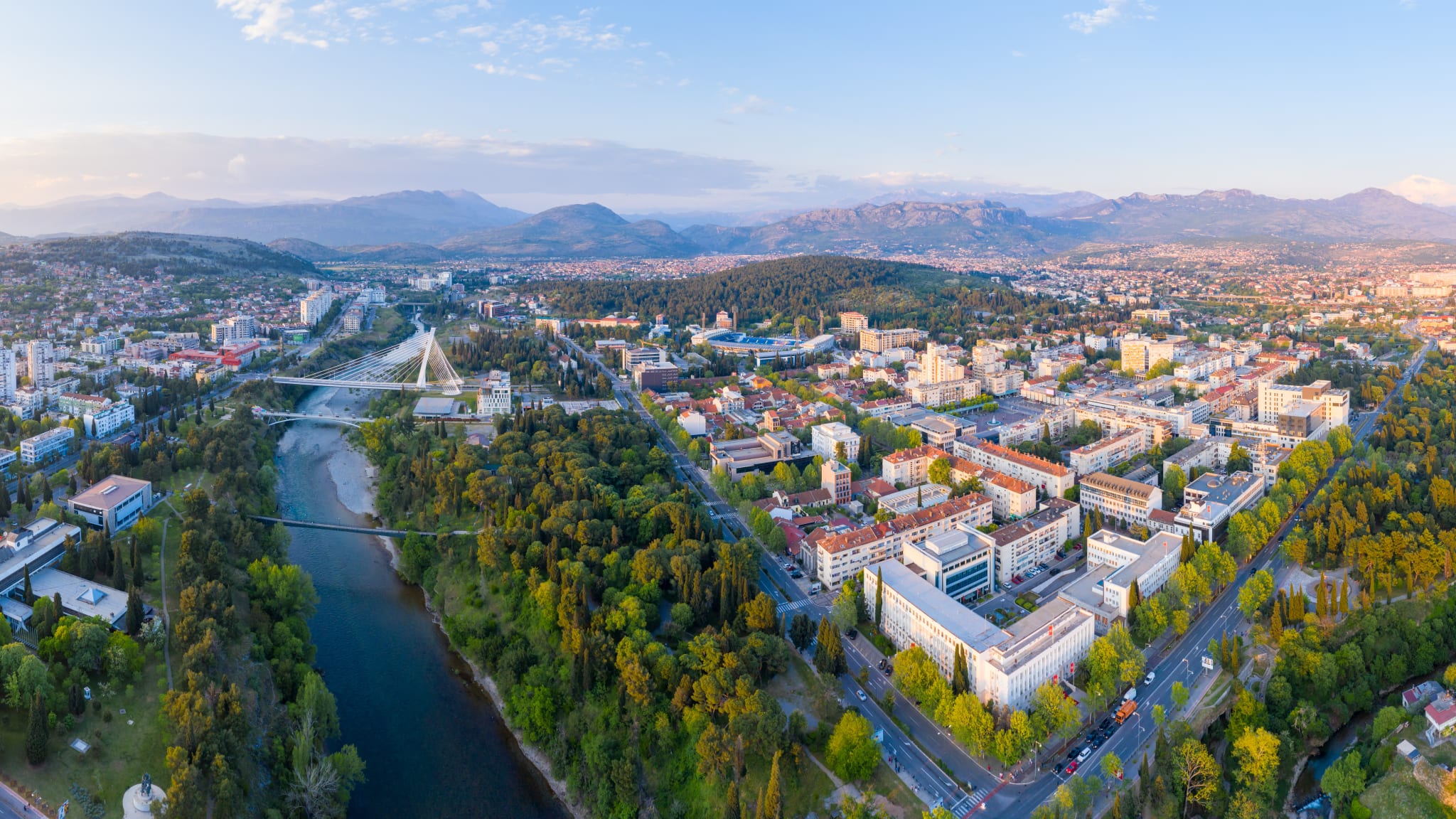 Blick auf eine Stadt mit einem Fluss und Bergen im Hintergrund