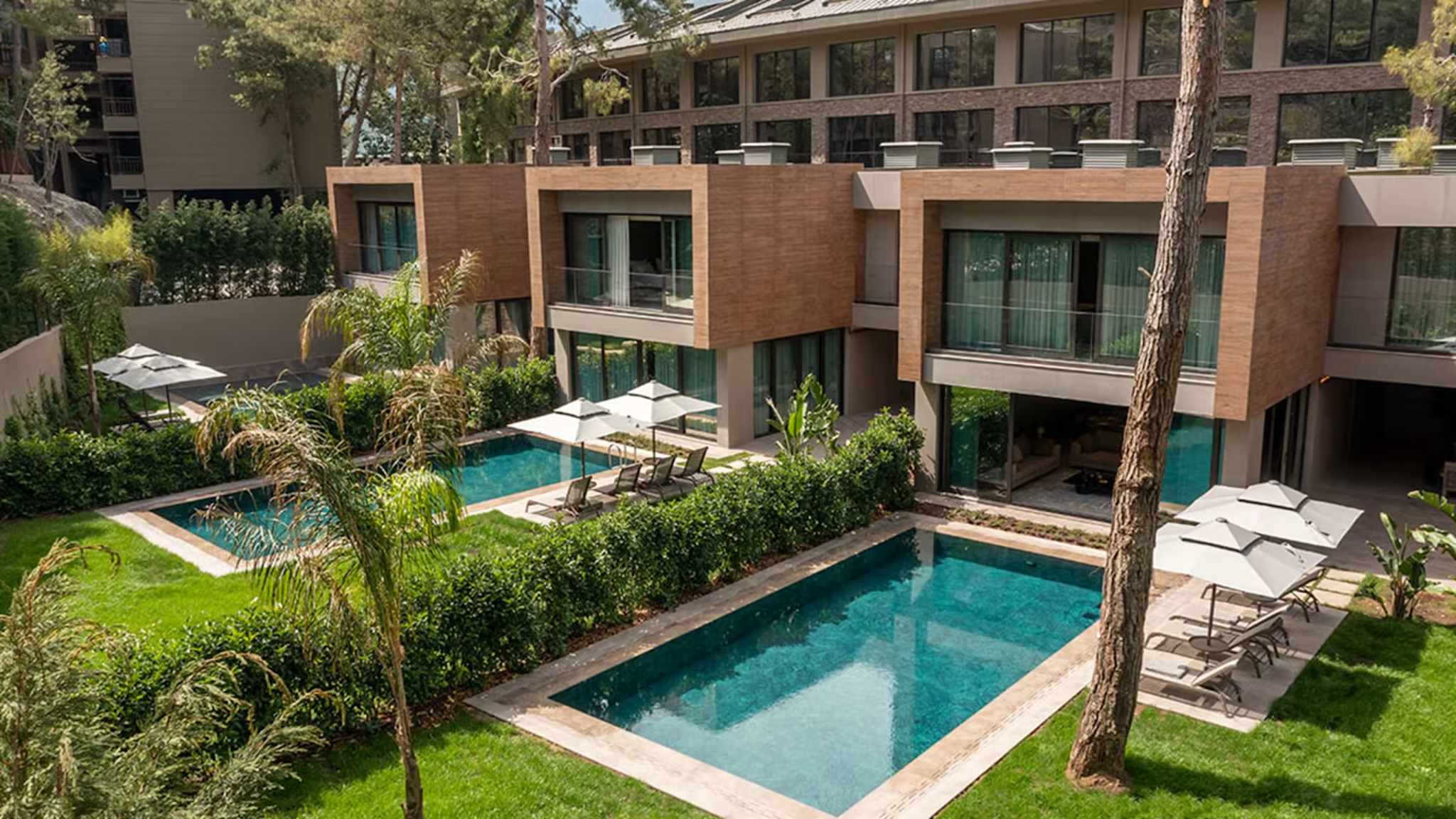 Mehrere Privatvillen nebeneinander mit Privatpool und Liegen