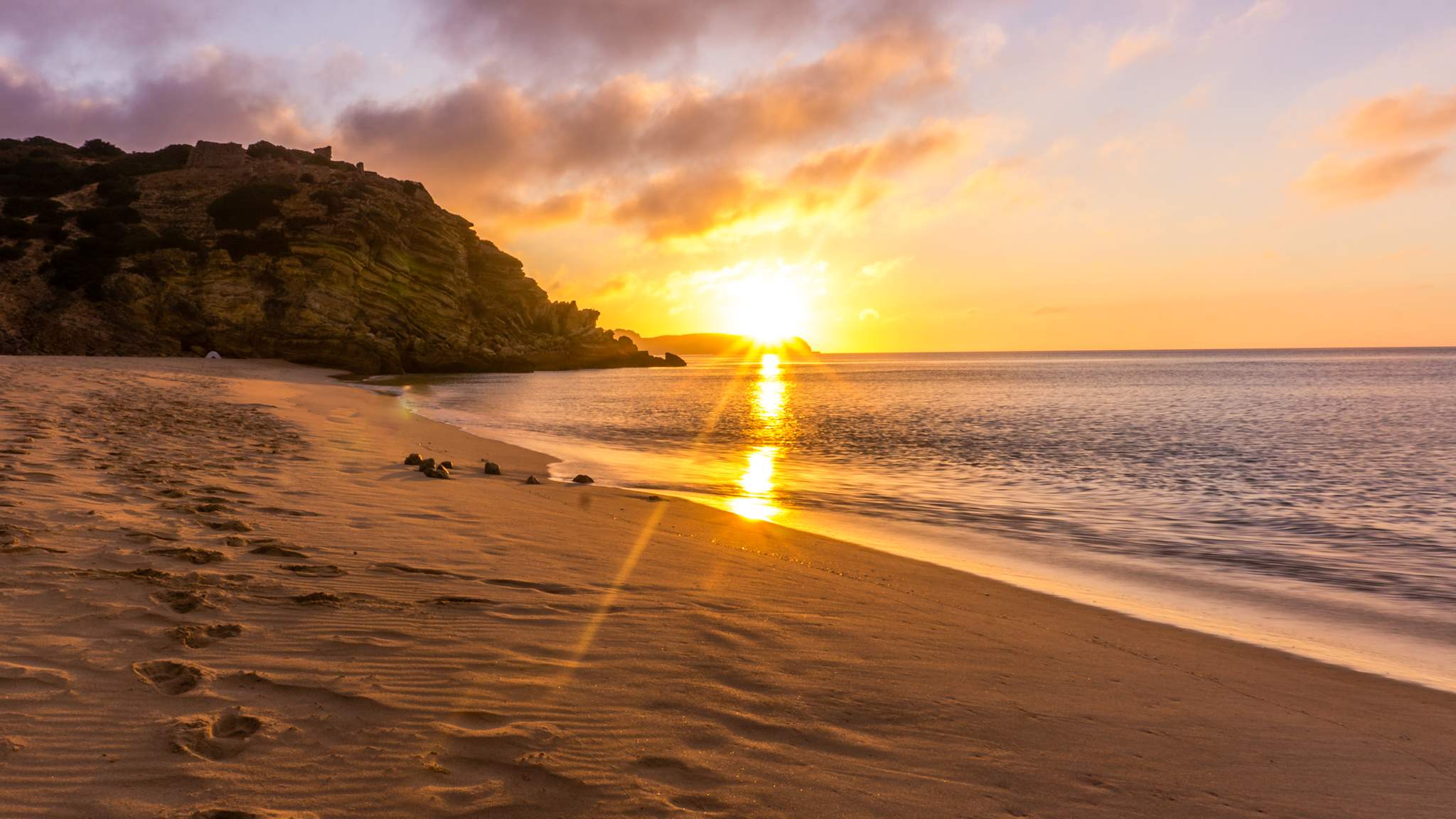 Sonnenuntergang hinter den Felsen am Strand