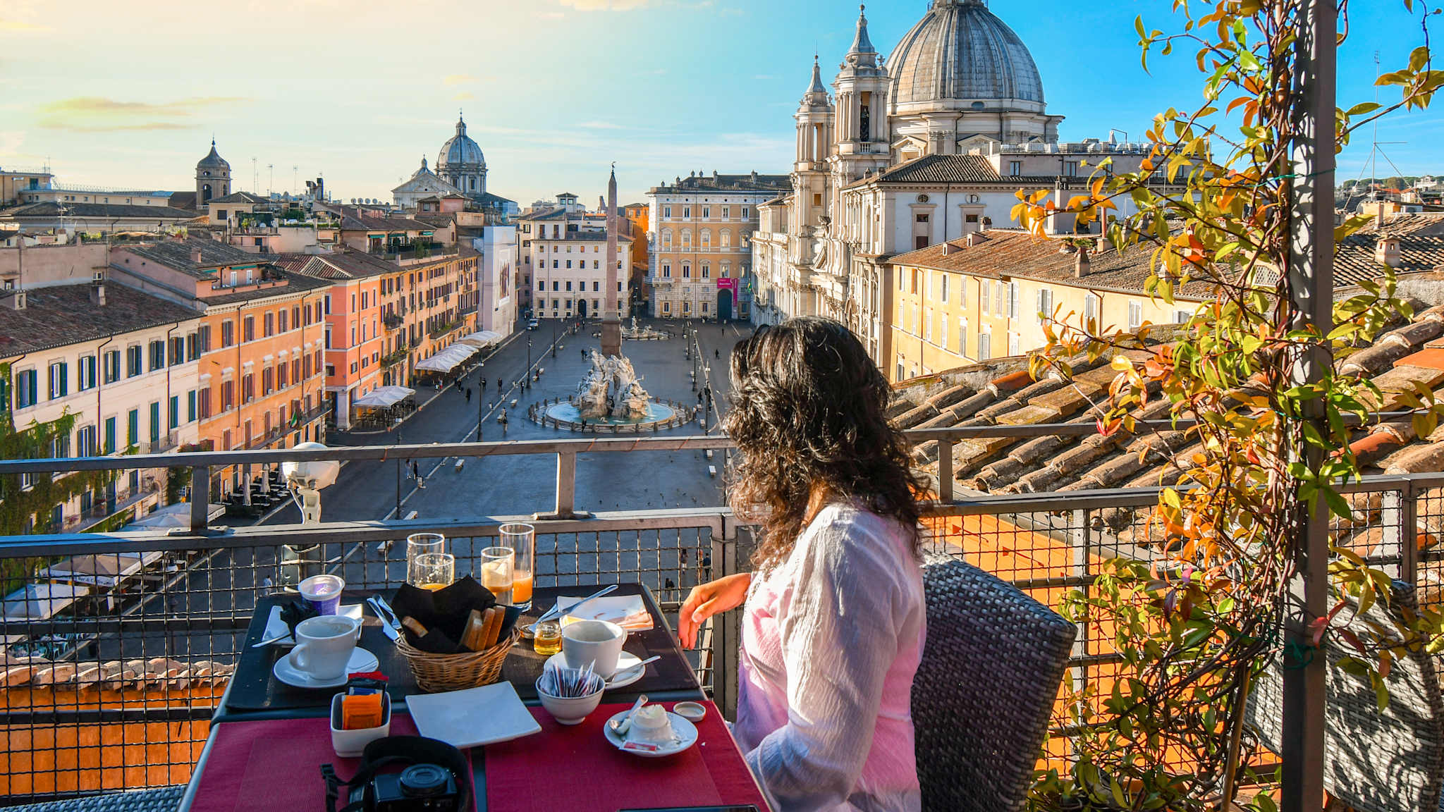 Eine Frau an einem Tisch blickt auf einen Platz