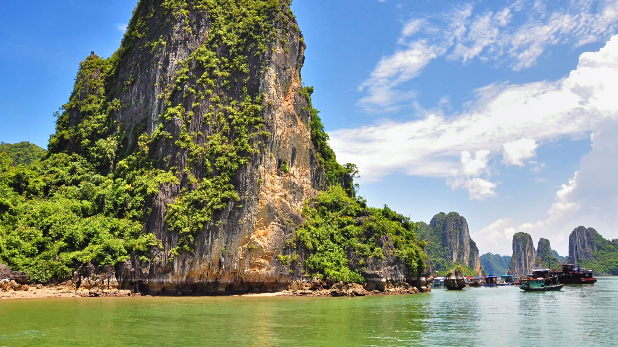 Riesiger Felsen und Boote an der Halong Bay, Vietnam.