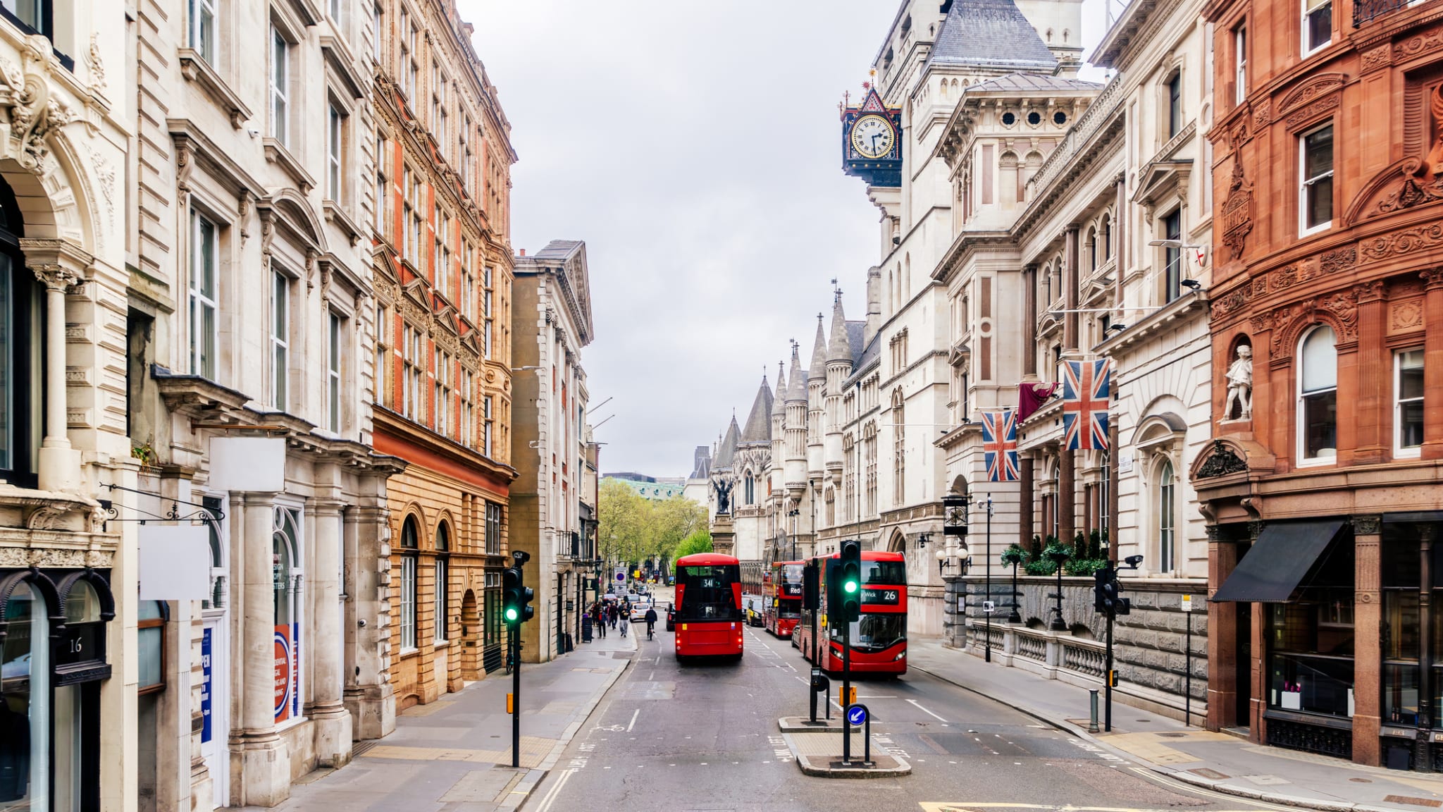 Rote Doppeldeckerbusse fahren durch eine Straße in der Innenstadt Londons.