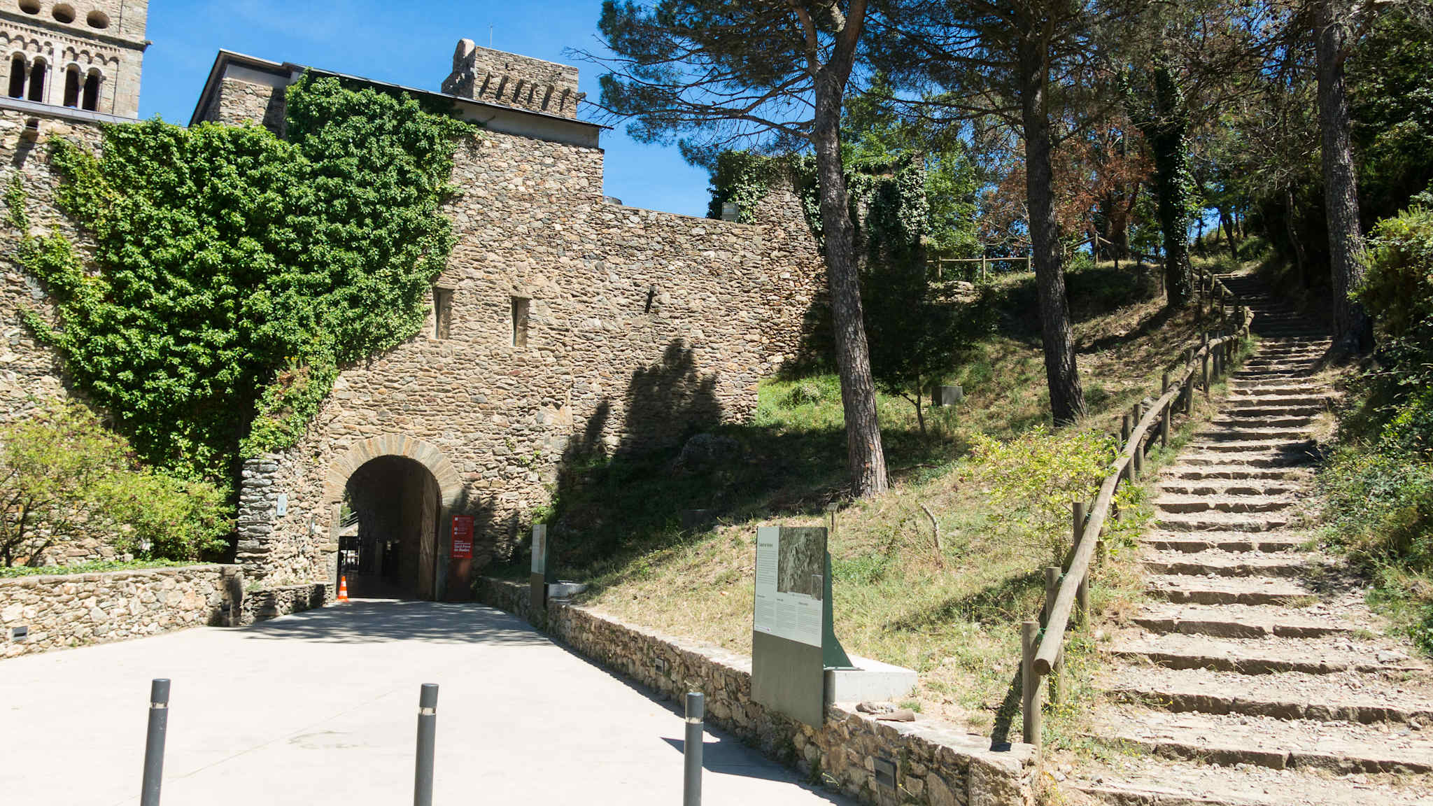 Ein Tor führt durch einen grün bewachsenen Wall.