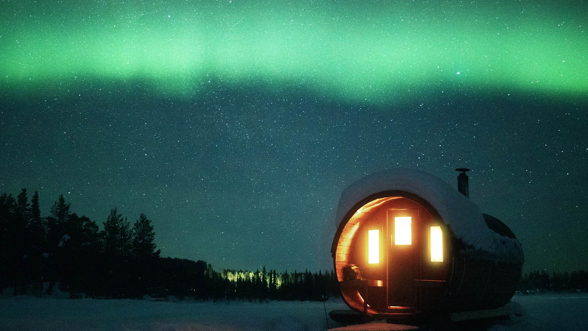Eine fassförmige Sauna unter den Nordlichtern