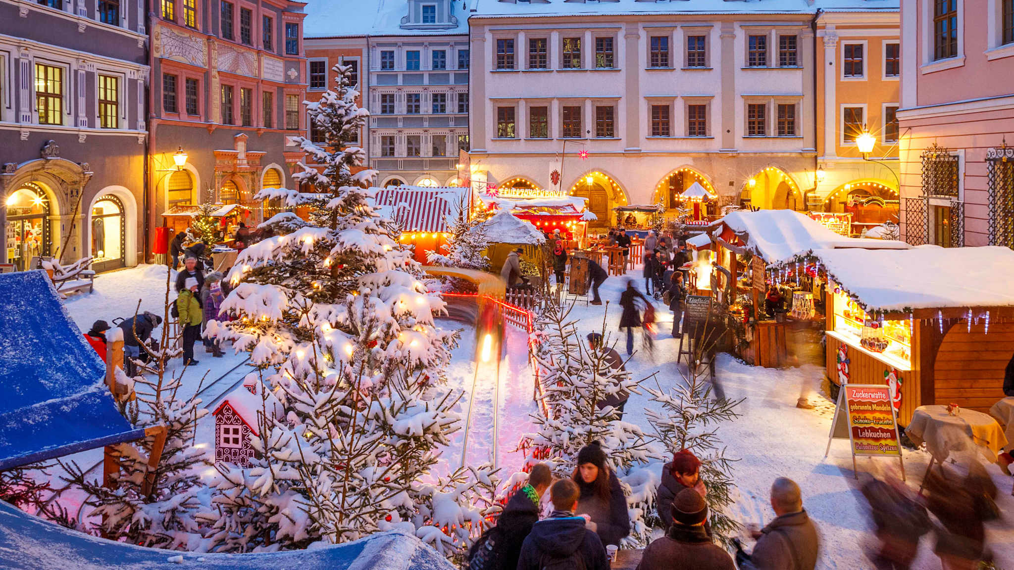 Verschneite Buden auf einem Platz.