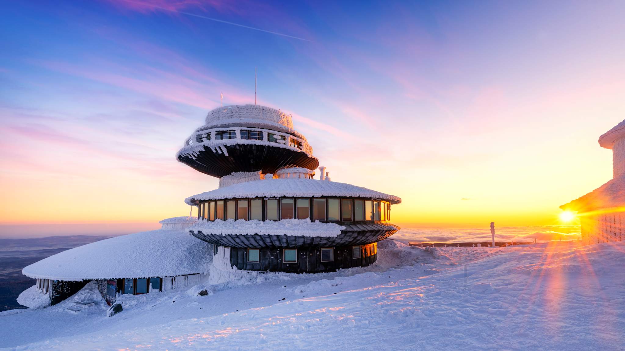 Ein verschneites Gebäude bei Sonnenuntergang
