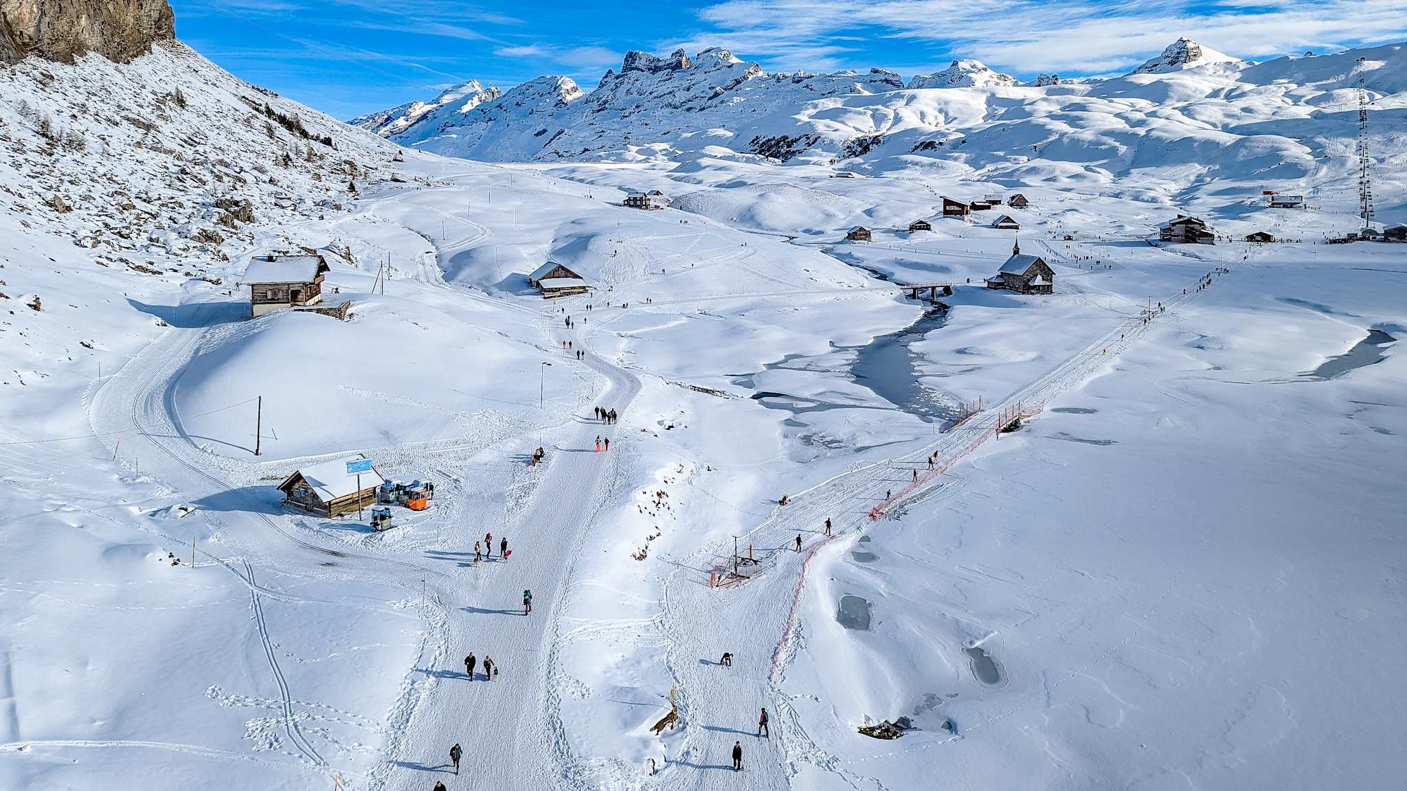 Skipisten und Hütten in einer verschneiten Berglandschaft.
