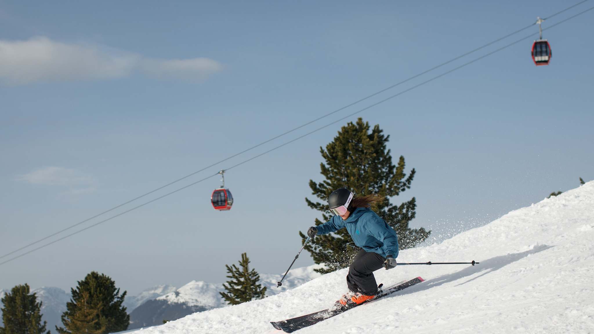 Eine Person fährt auf Skiern eine Hang hinunter.