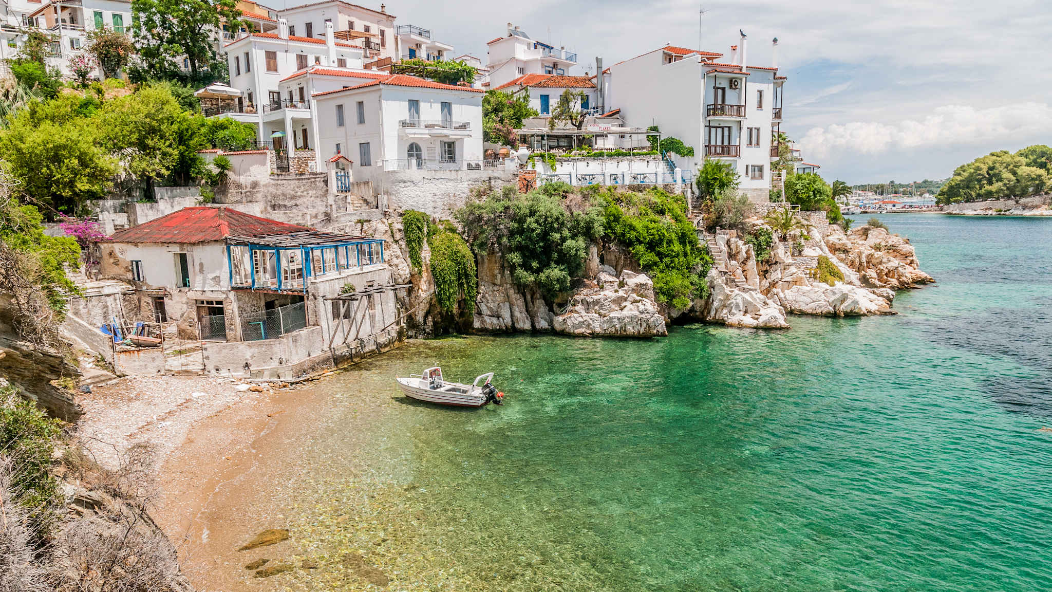 Sicht auf eine städtische Bucht mit einem alten Hafen, ein Boot liegt vor Anker.
