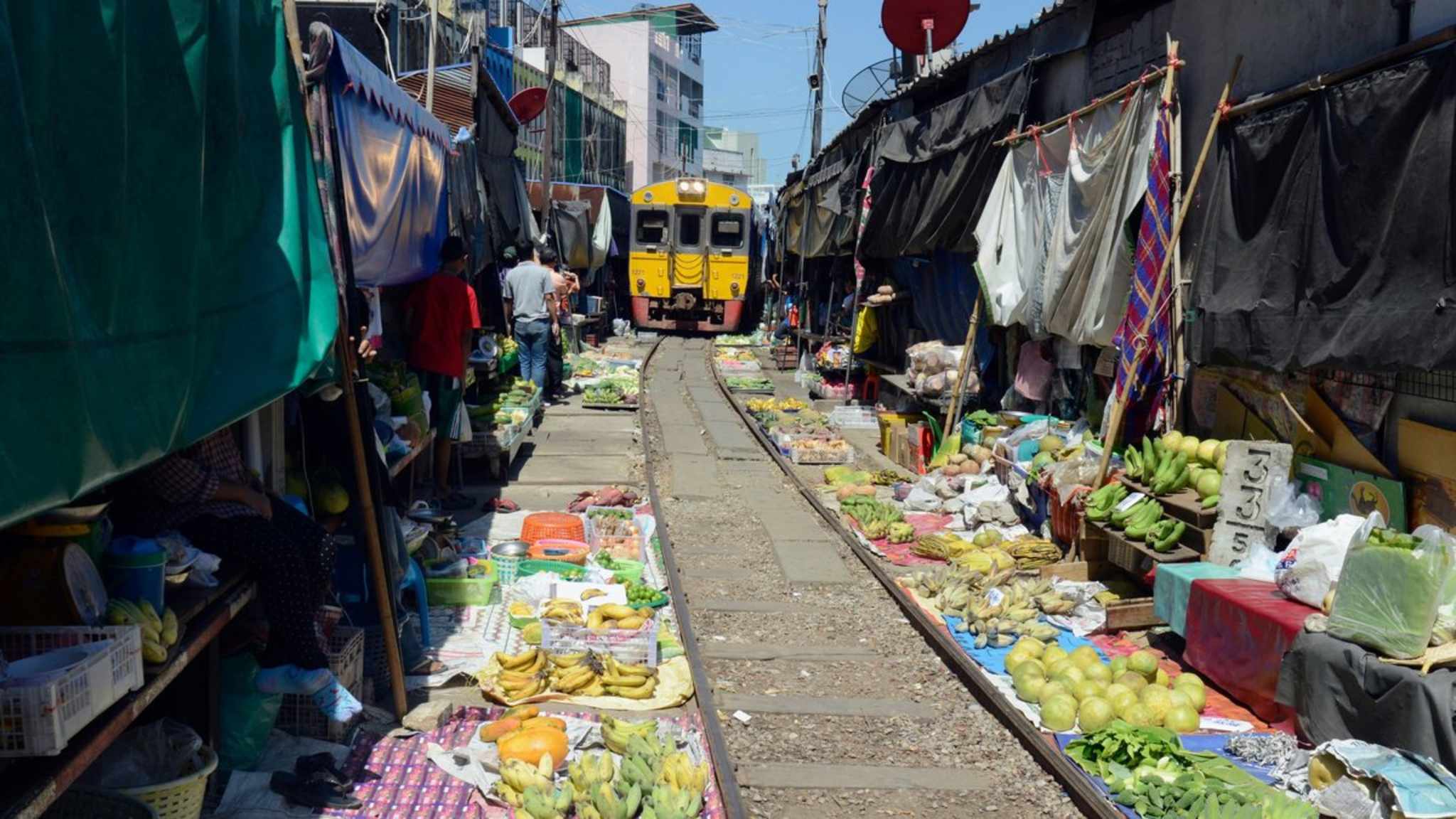 In der Nähe von Bangkok müssen die HändlerInnen des "Mae Klong" ihre Ware regelmäßig vor einem Zug in Sicherheit bringen. © amnat30/ SHutterstock.com