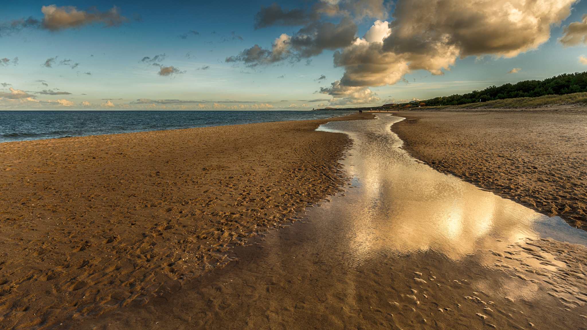 Wolken über Strand und Meer.