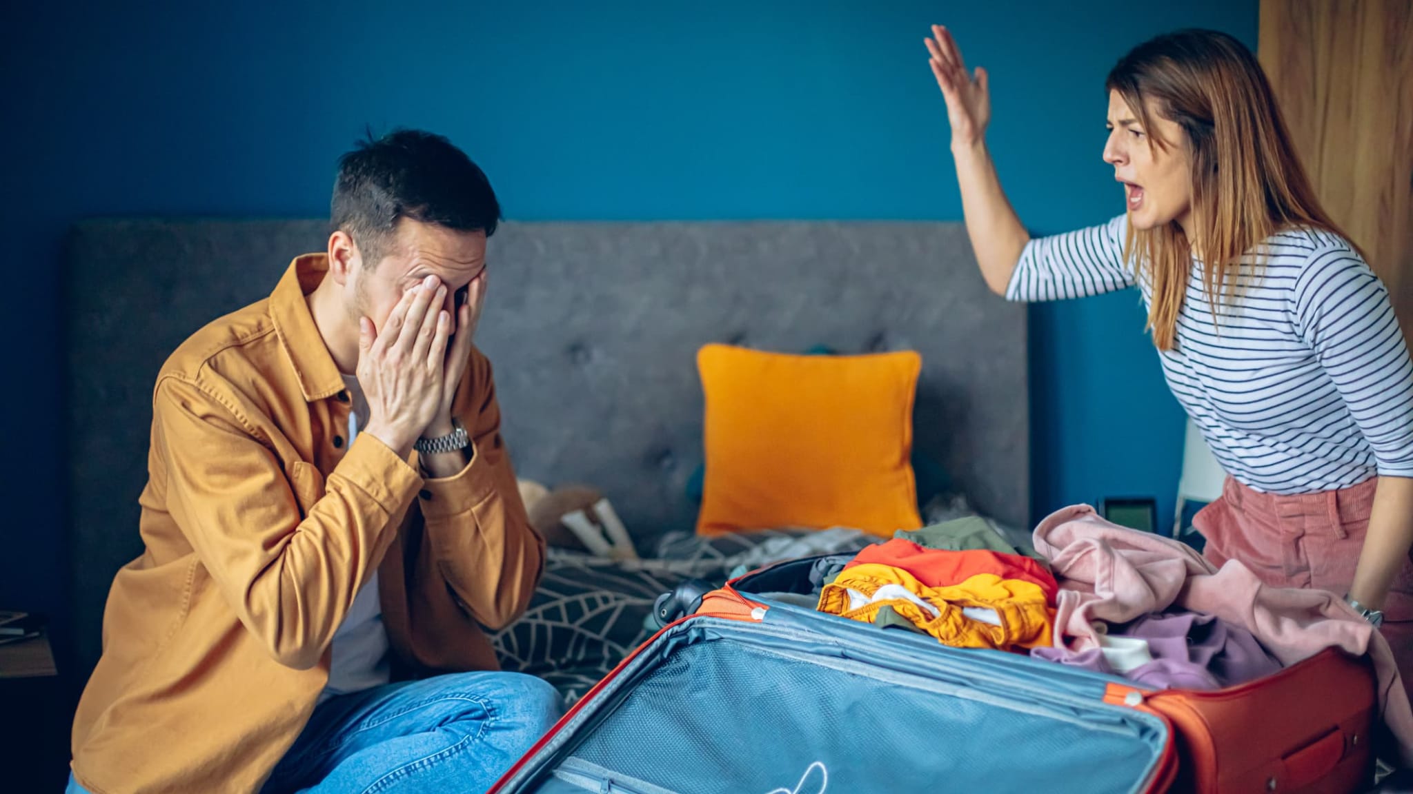 Streitendes Paar beim Kofferpacken.