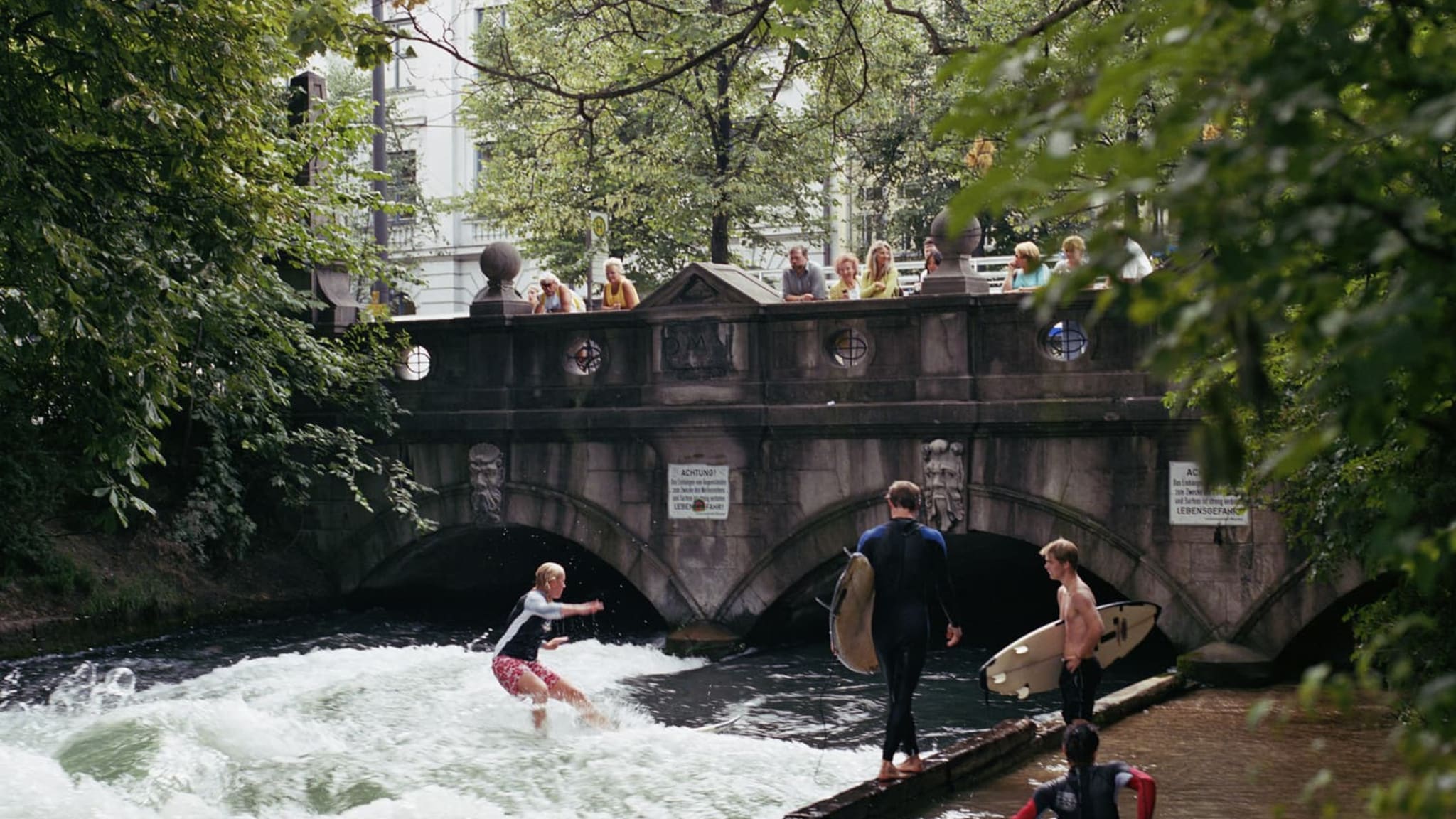 SurferInnen an der Eisbachwelle, München, Bayern, Deutschland