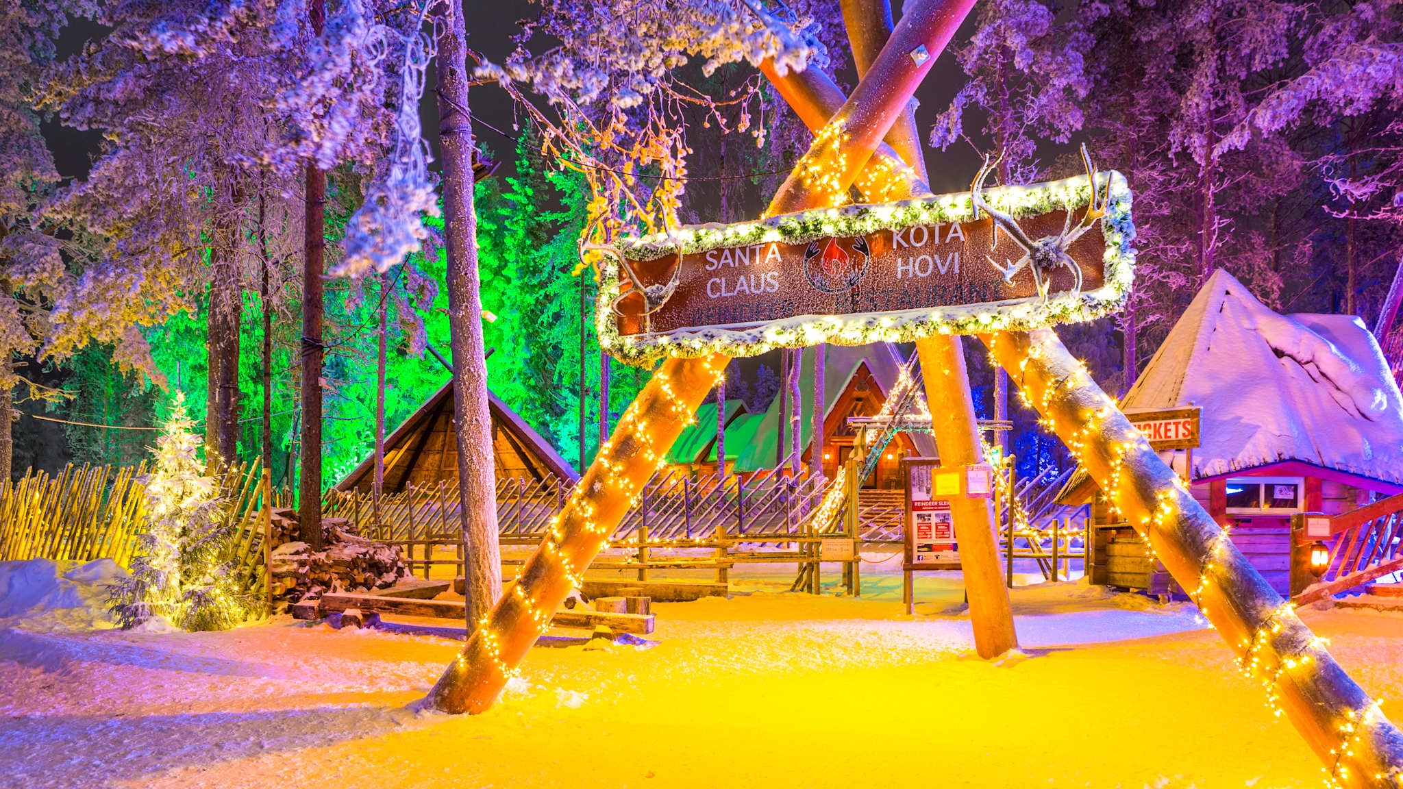 Blick auf ein bunt beleuchtetes Dorf im Schnee