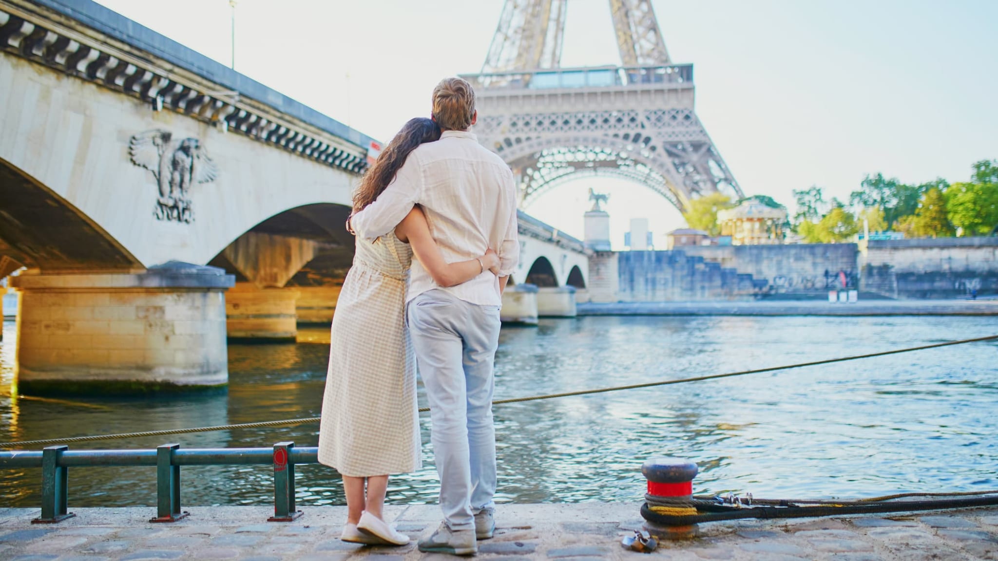 Umarmendes Paar vor dem Eiffelturm in Paris.