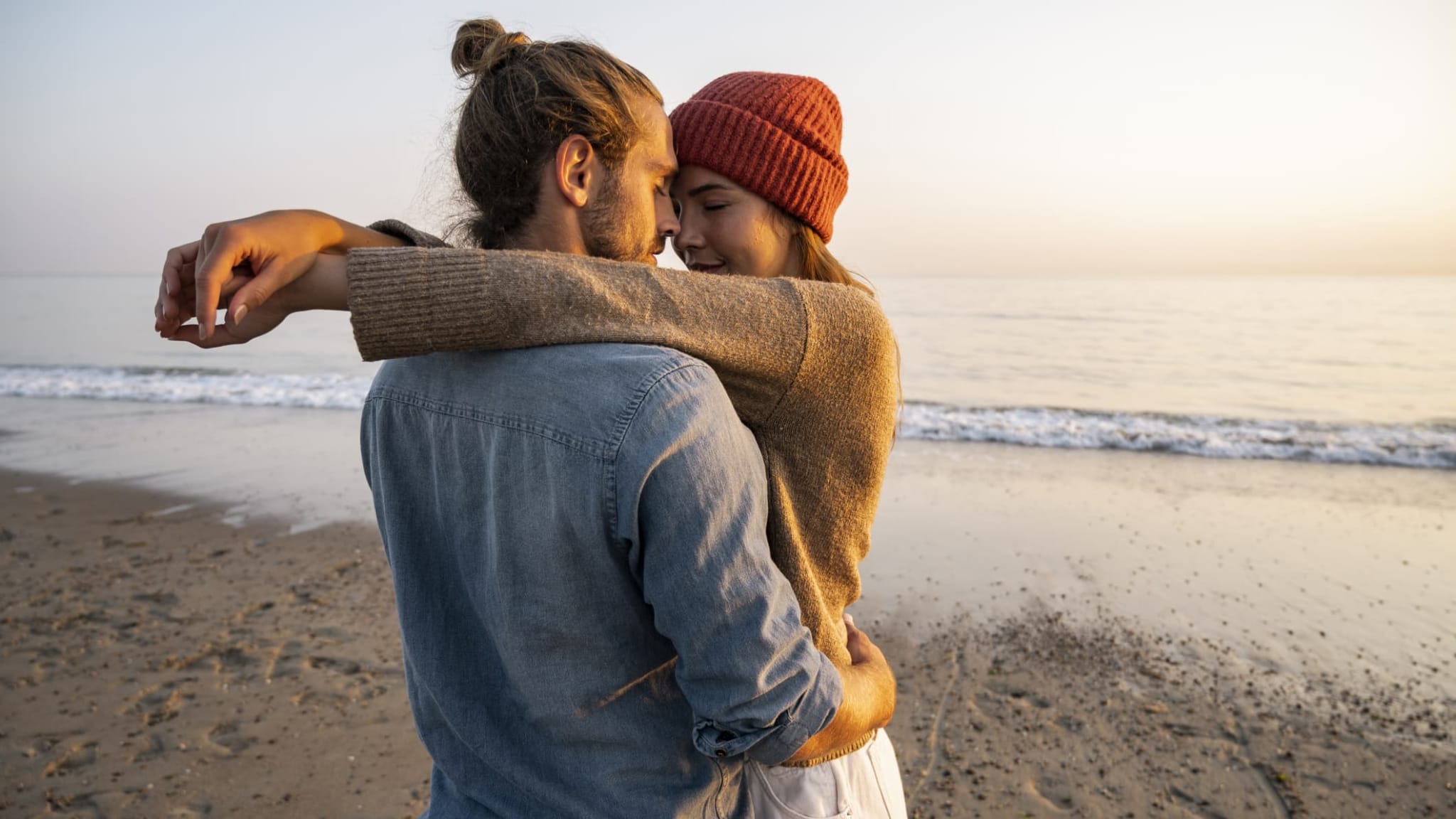 Ein umarmendes Pärchen am Strand.